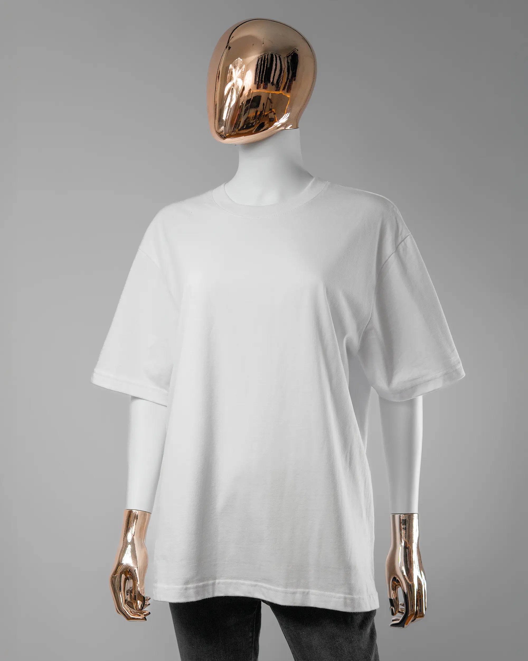 Vorderseite des Basic Unisex T-Shirt Oversized von Maondo ohne Motiv in der Farbe White und in der Größe S getragen von einer femininen Puppe