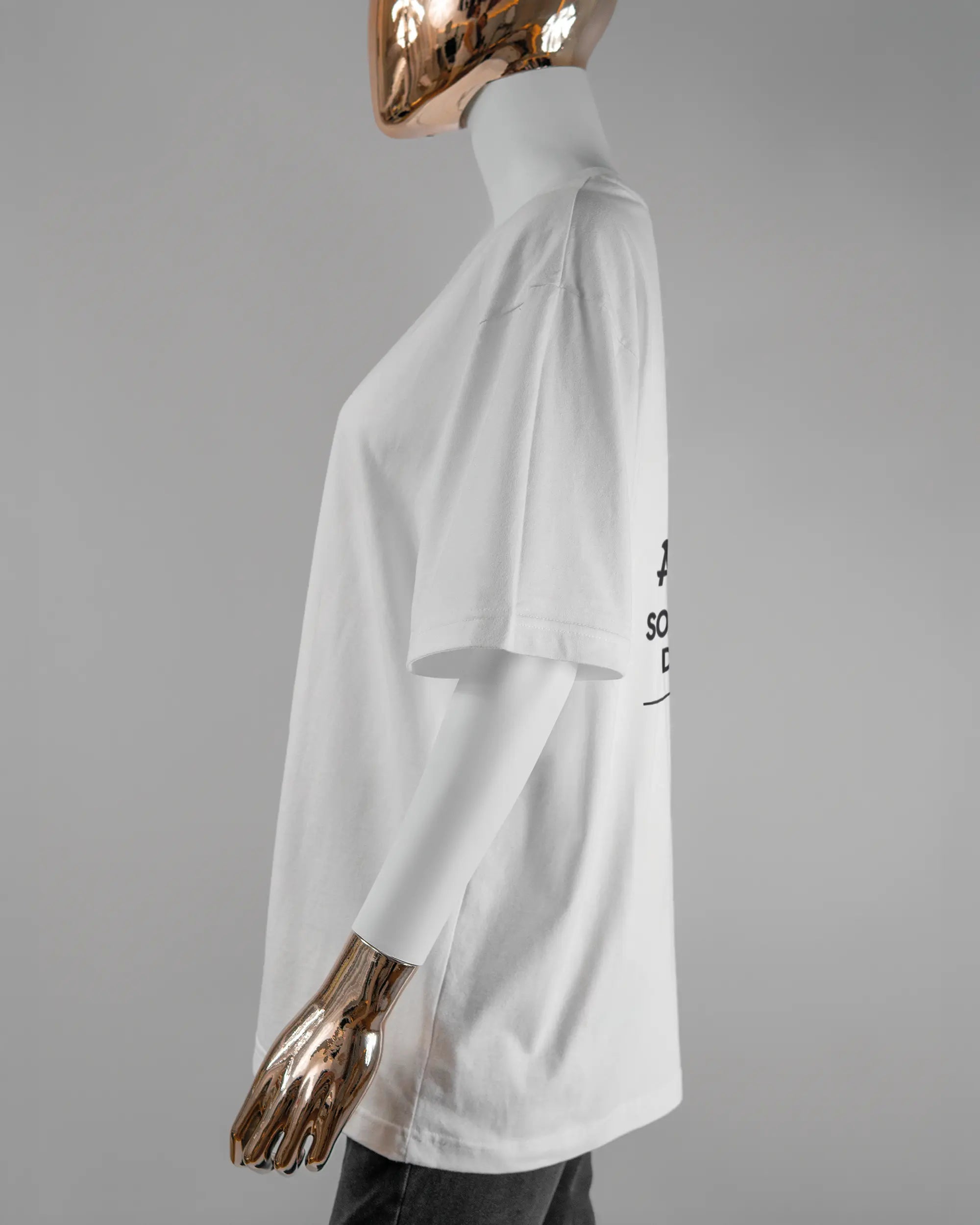 Seitenansicht des Basic Unisex T-Shirt Oversized von Maondo mit dem Design Eins nach dem Annern hinten in der Farbe White und in der Größe S getragen von einer femininen Puppe