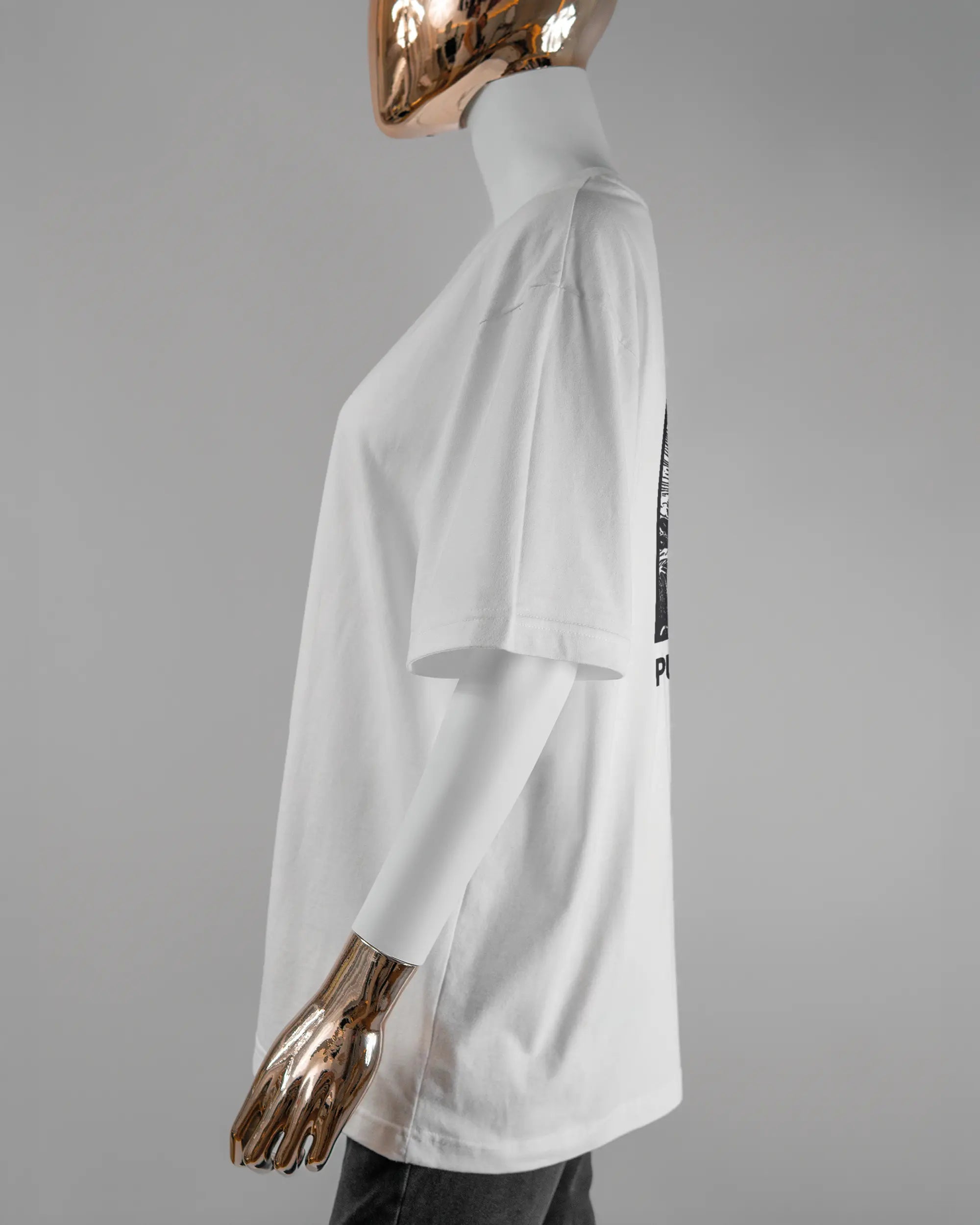 Seitenansicht des Basic Unisex T-Shirt Oversized von Maondo mit dem Design Puny Human hinten in der Farbe White und in der Größe S getragen von einer femininen Puppe