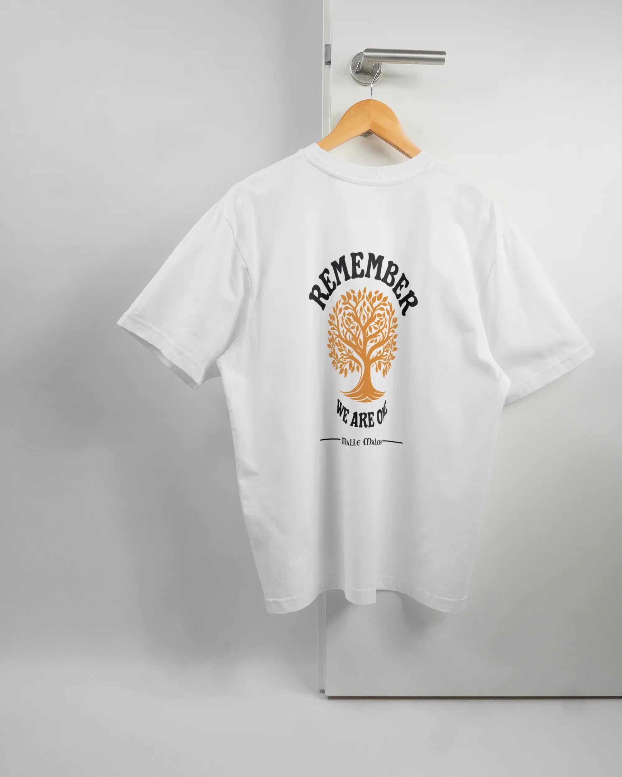 Rückseite des Basic Unisex T-Shirt Oversized von Maondo mit dem Design We are one in der Farbe White und in der Größe S auf einem Bügel an der Türklinke aufgehängt