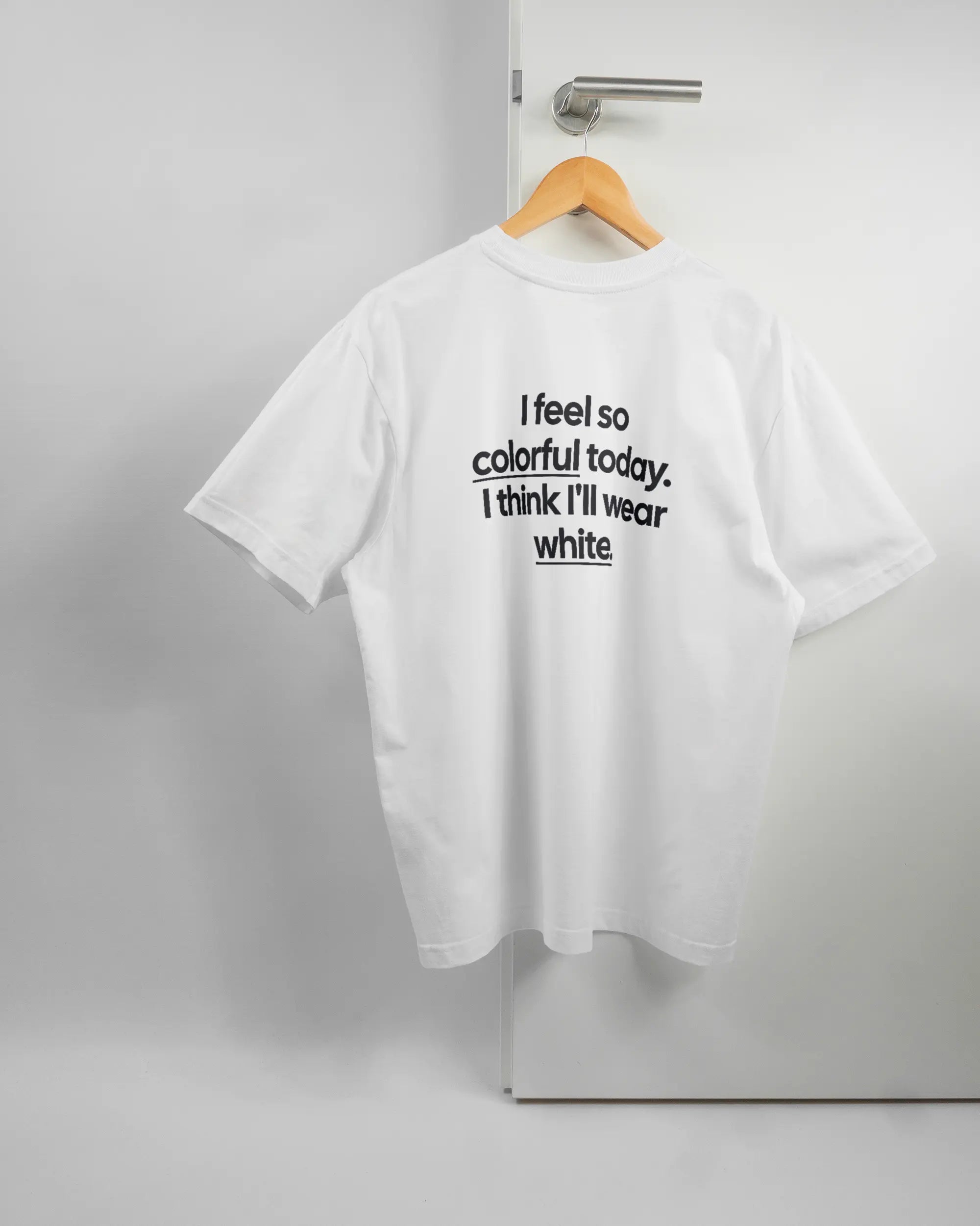 Rückseite des Basic Unisex T-Shirt Oversized von Maondo mit dem Design Colorful Day in der Farbe White und in der Größe S auf einem Bügel an der Türklinke aufgehängt