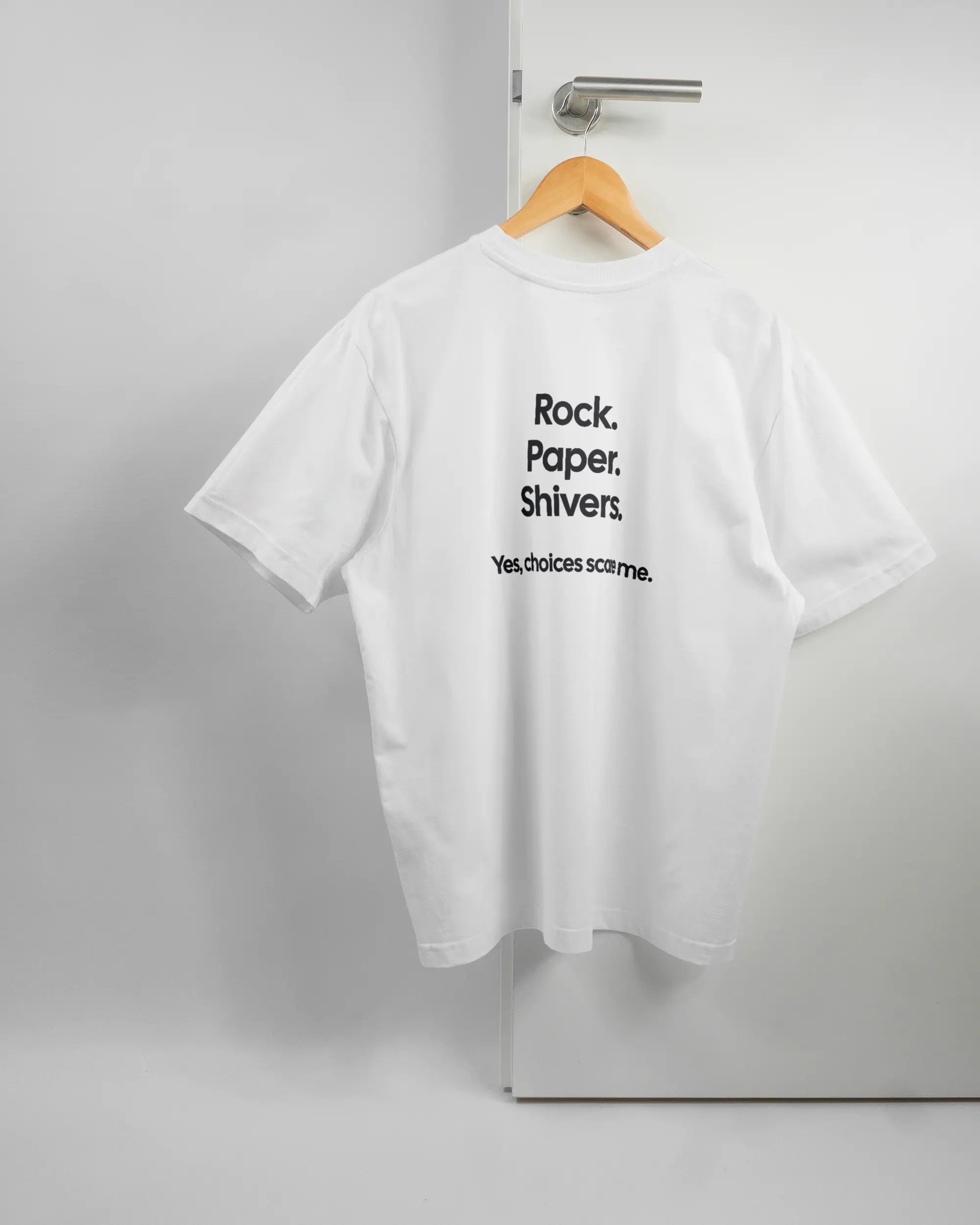 Rückseite des Basic Unisex T-Shirt Oversized von Maondo mit dem Design Rock Paper Shivers in der Farbe White und in der Größe S auf einem Bügel an der Türklinke aufgehängt