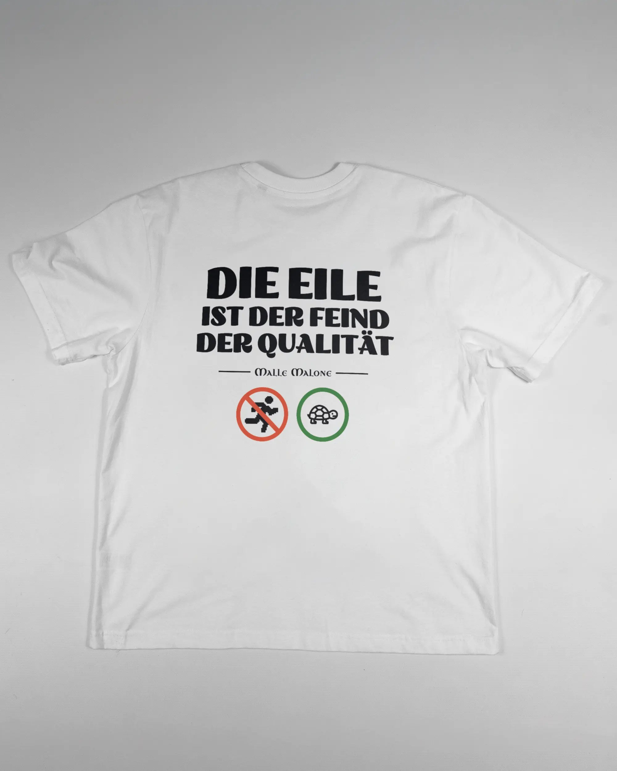 Rückseite des Basic Unisex T-Shirt Oversized von Maondo mit dem Design Keine Eile in der Farbe White und in der Größe S flach auf den Boden gelegt