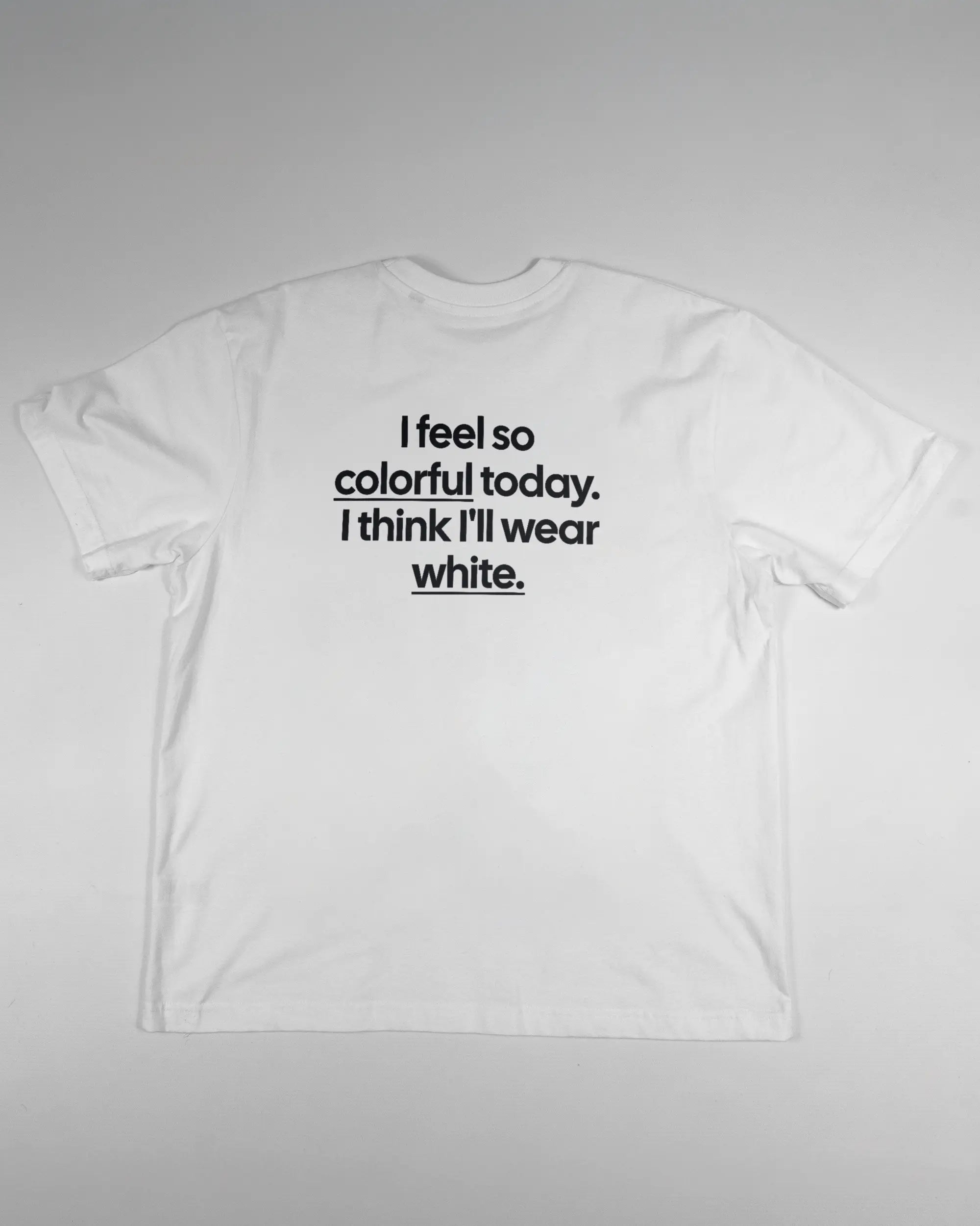 Rückseite des Basic Unisex T-Shirt Oversized von Maondo mit dem Design Colorful Day in der Farbe White und in der Größe S flach auf den Boden gelegt