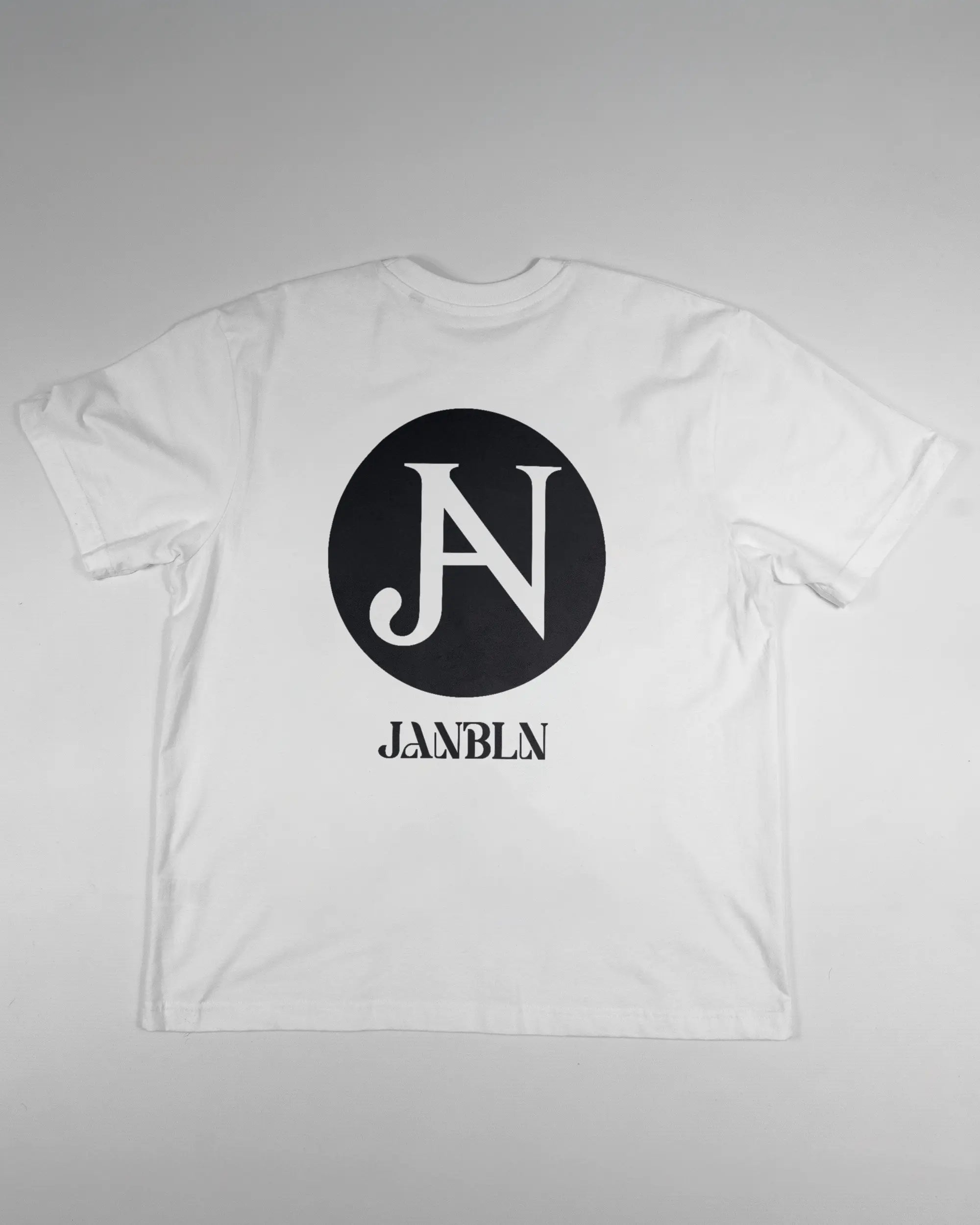 Rückseite des Basic Unisex T-Shirt Oversized von Maondo mit dem Design JB1 in der Farbe White und in der Größe S flach auf den Boden gelegt