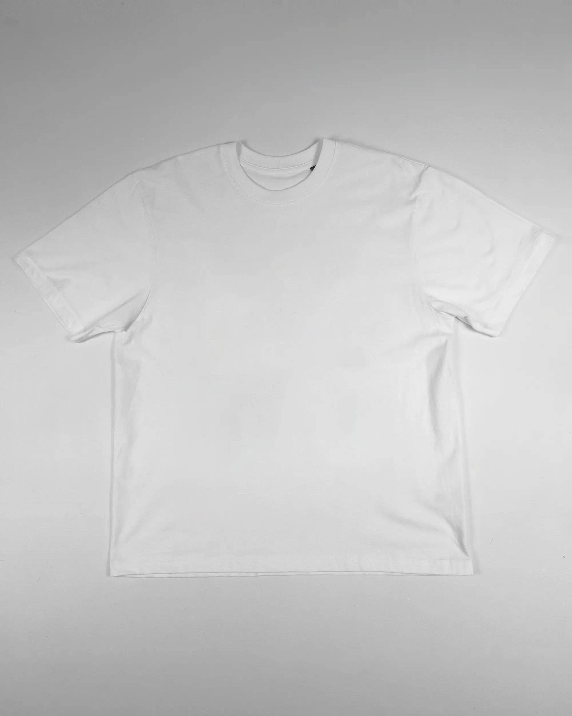 Vorderseite des Basic Unisex T-Shirt Oversized von Maondo ohne Motiv in der Farbe White und in der Größe S flach auf den Boden gelegt