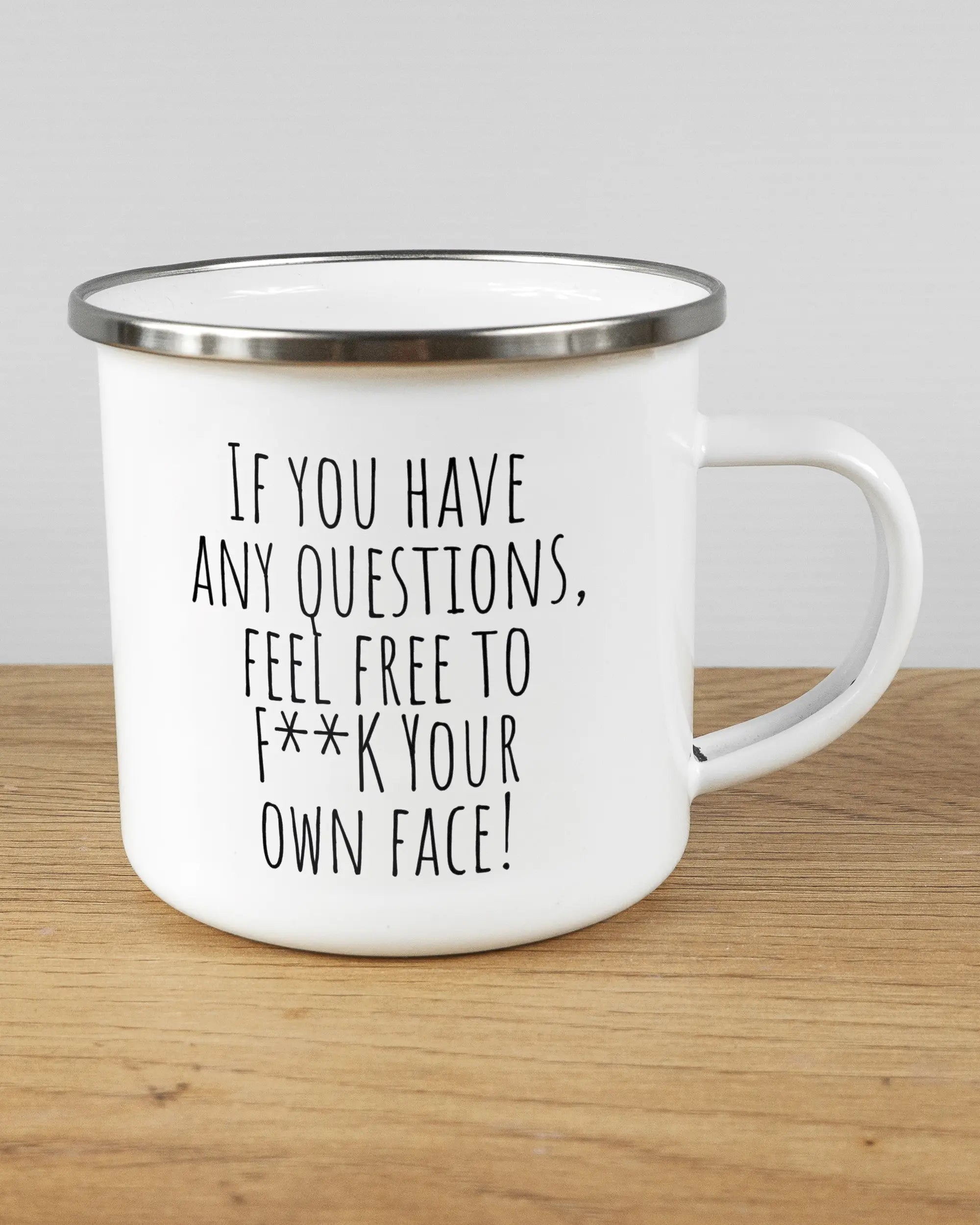 Alternativbild, das die rechte Seite der beidseitig bedruckten Emailletasse von Maondo mit dem Design Feel Free in der Farbe White-Silver auf einem Holztisch zeigt