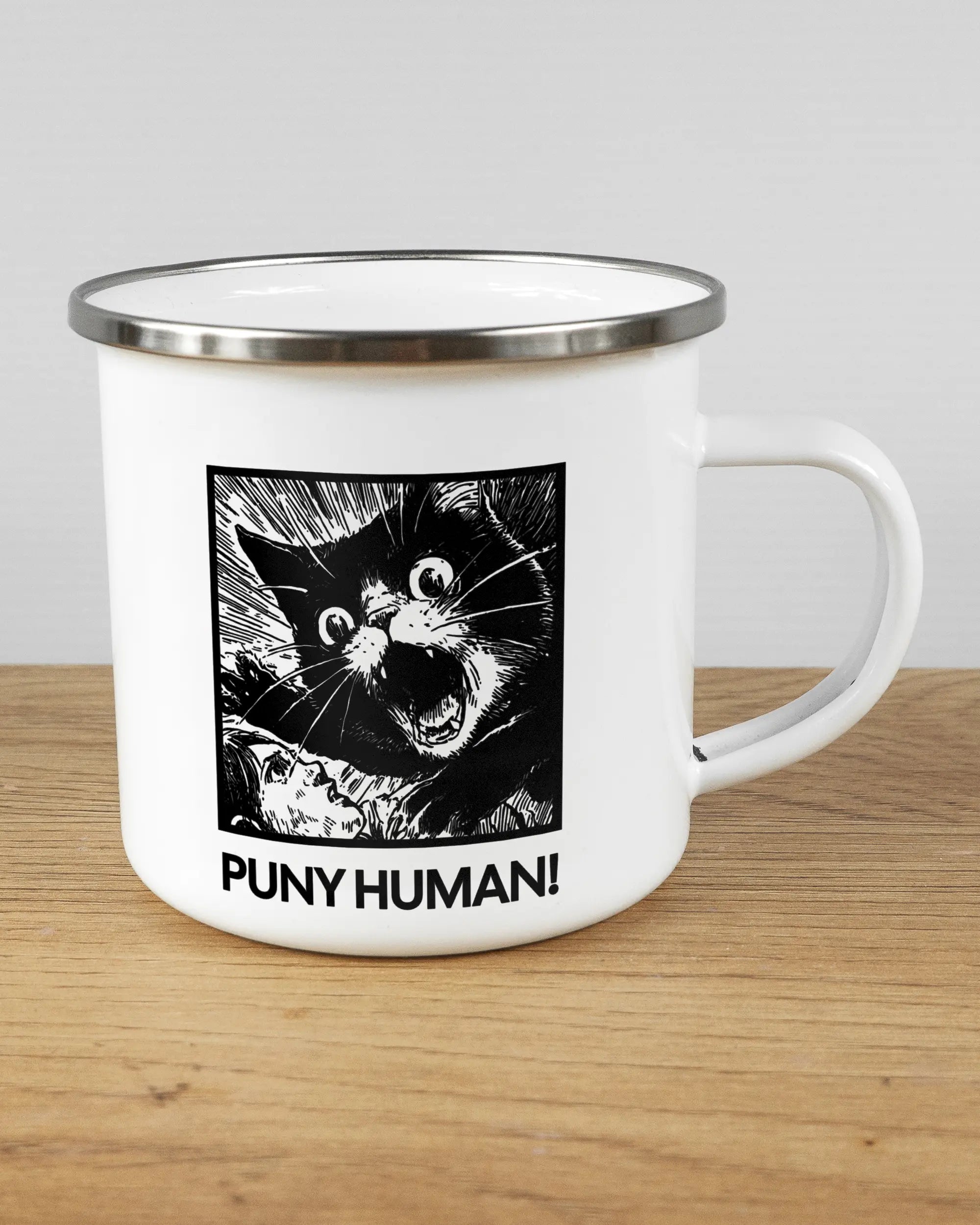 Alternativbild, das die rechte Seite der beidseitig bedruckten Emailletasse von Maondo mit dem Design Puny Human in der Farbe White-Silver auf einem Holztisch zeigt