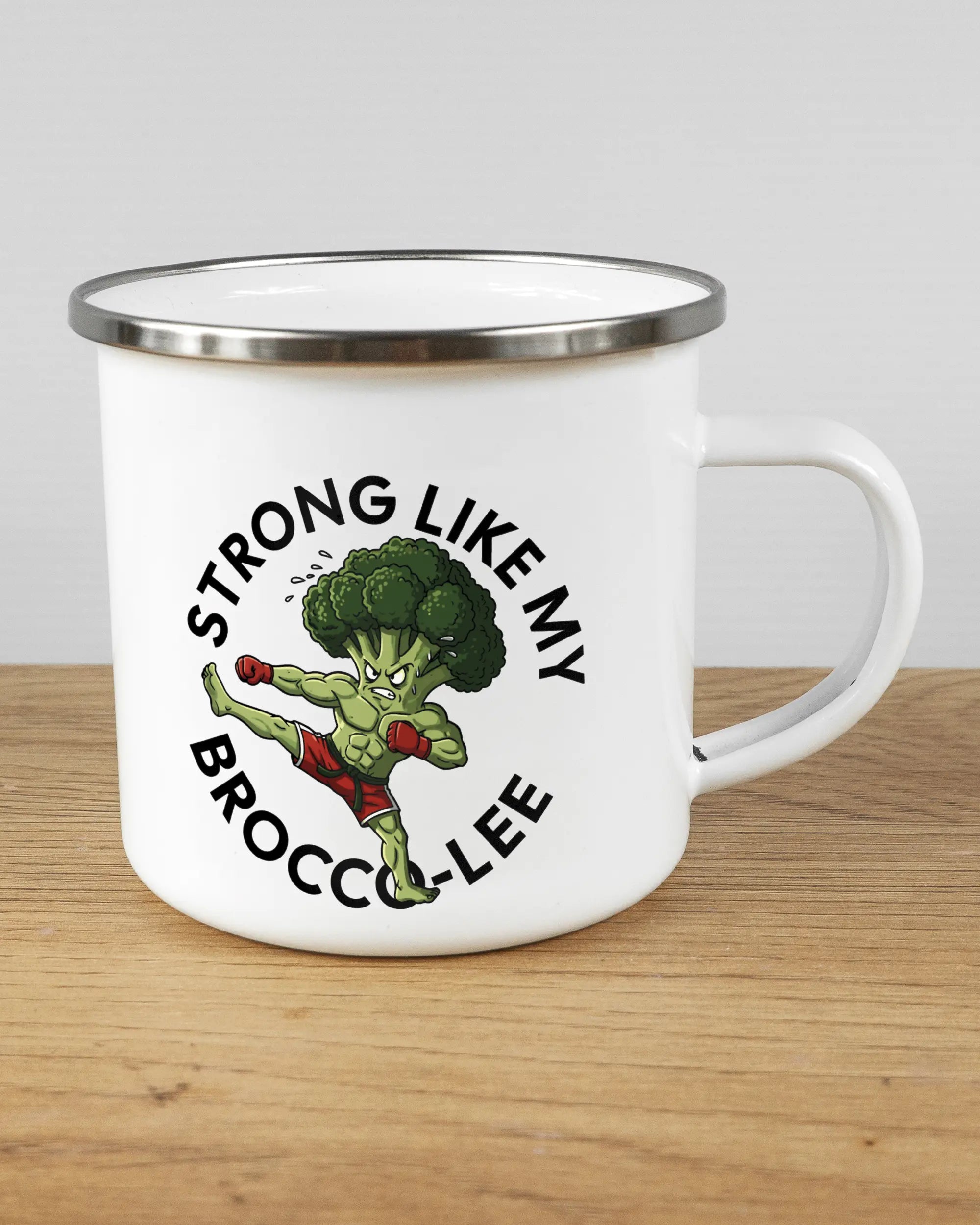 Alternativbild, das die rechte Seite der beidseitig bedruckten Emailletasse von Maondo mit dem Design Brocco-Lee in der Farbe White-Silver auf einem Holztisch zeigt