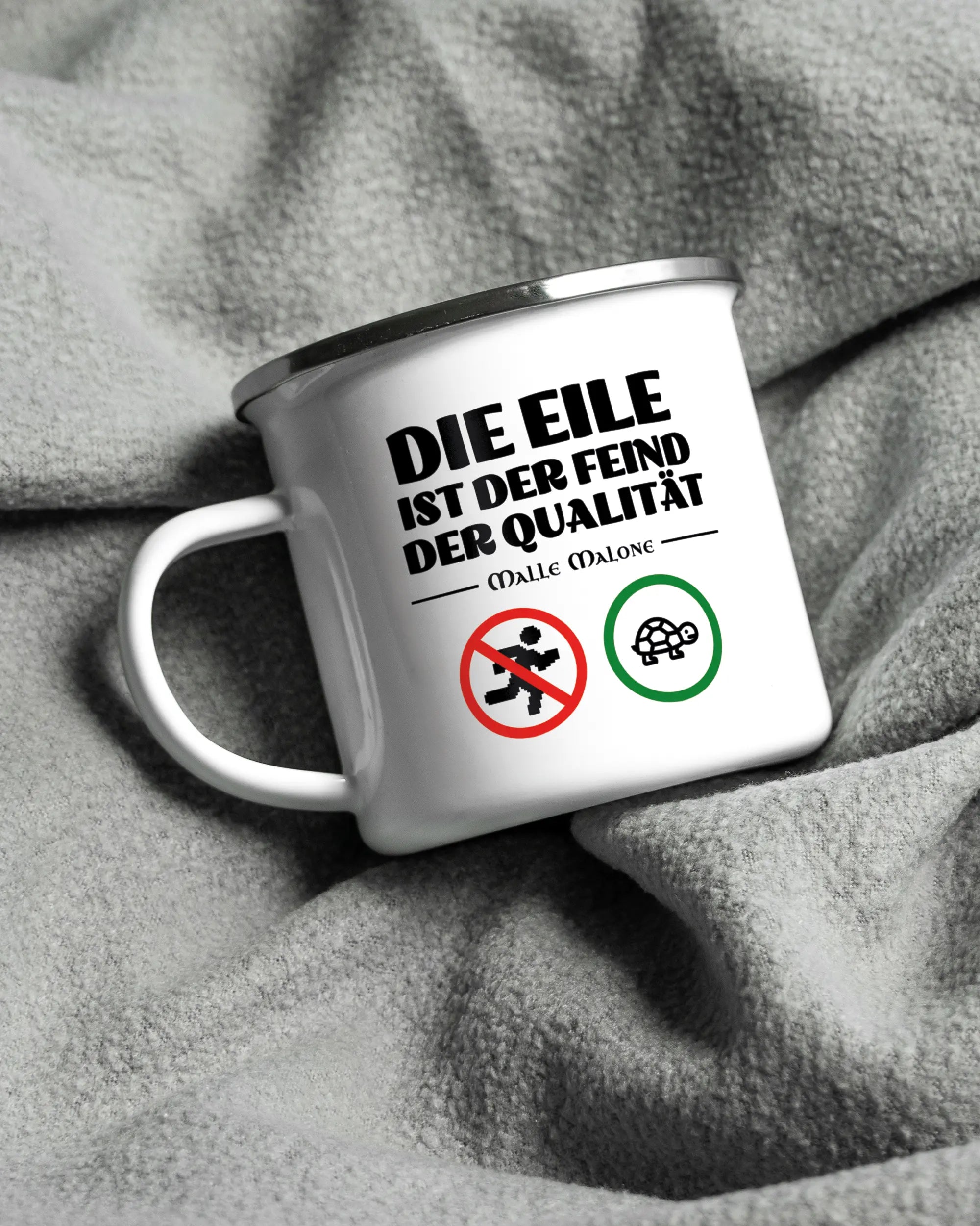 Aufnahme, die die linke Seite der beidseitig bedruckten Emailletasse von Maondo auf einer flauschigen Fließdecke mit dem Design White-Silver in der Farbe  zeigt