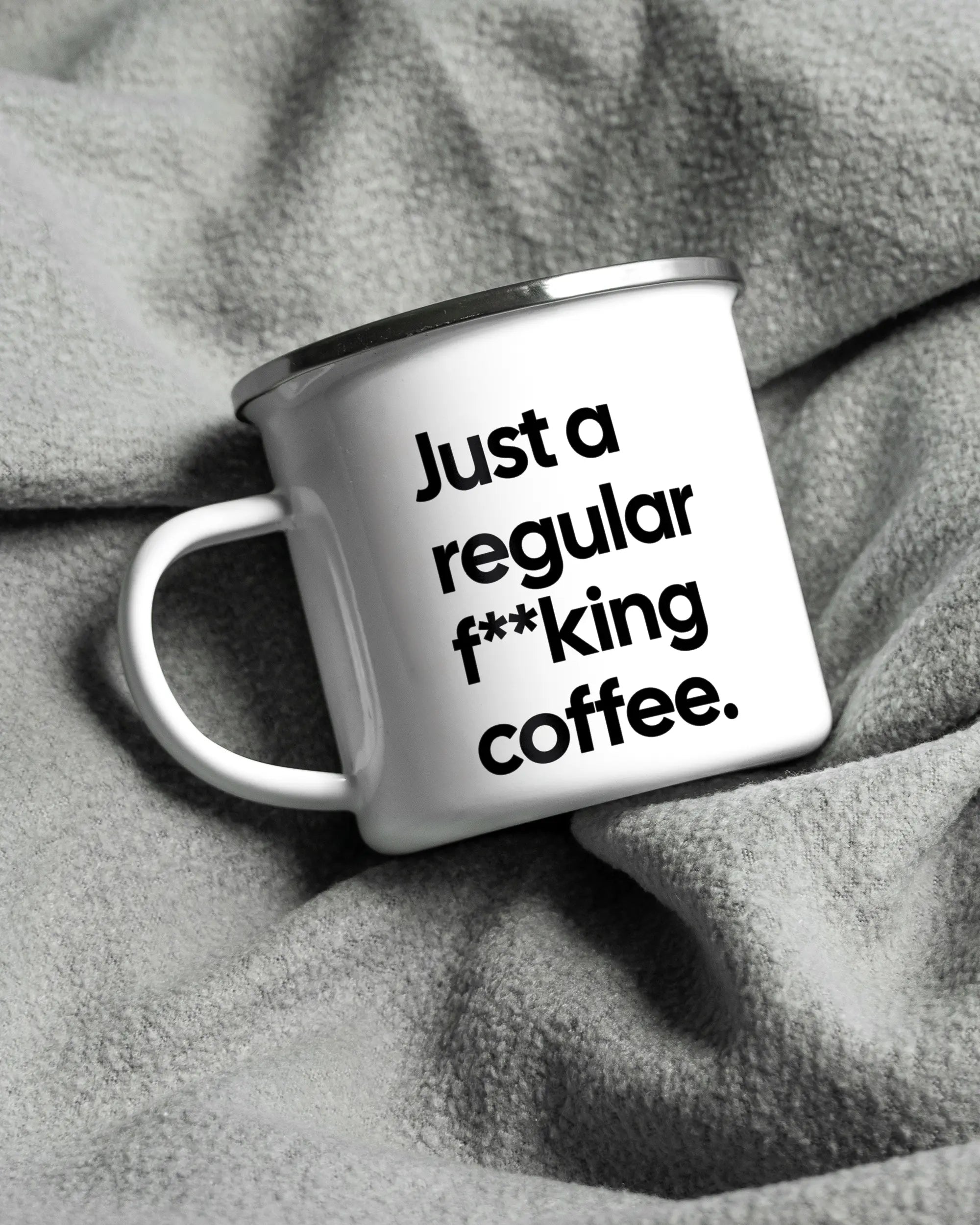 Aufnahme, die die linke Seite der beidseitig bedruckten Emailletasse von Maondo auf einer flauschigen Fließdecke mit dem Design White-Silver in der Farbe  zeigt