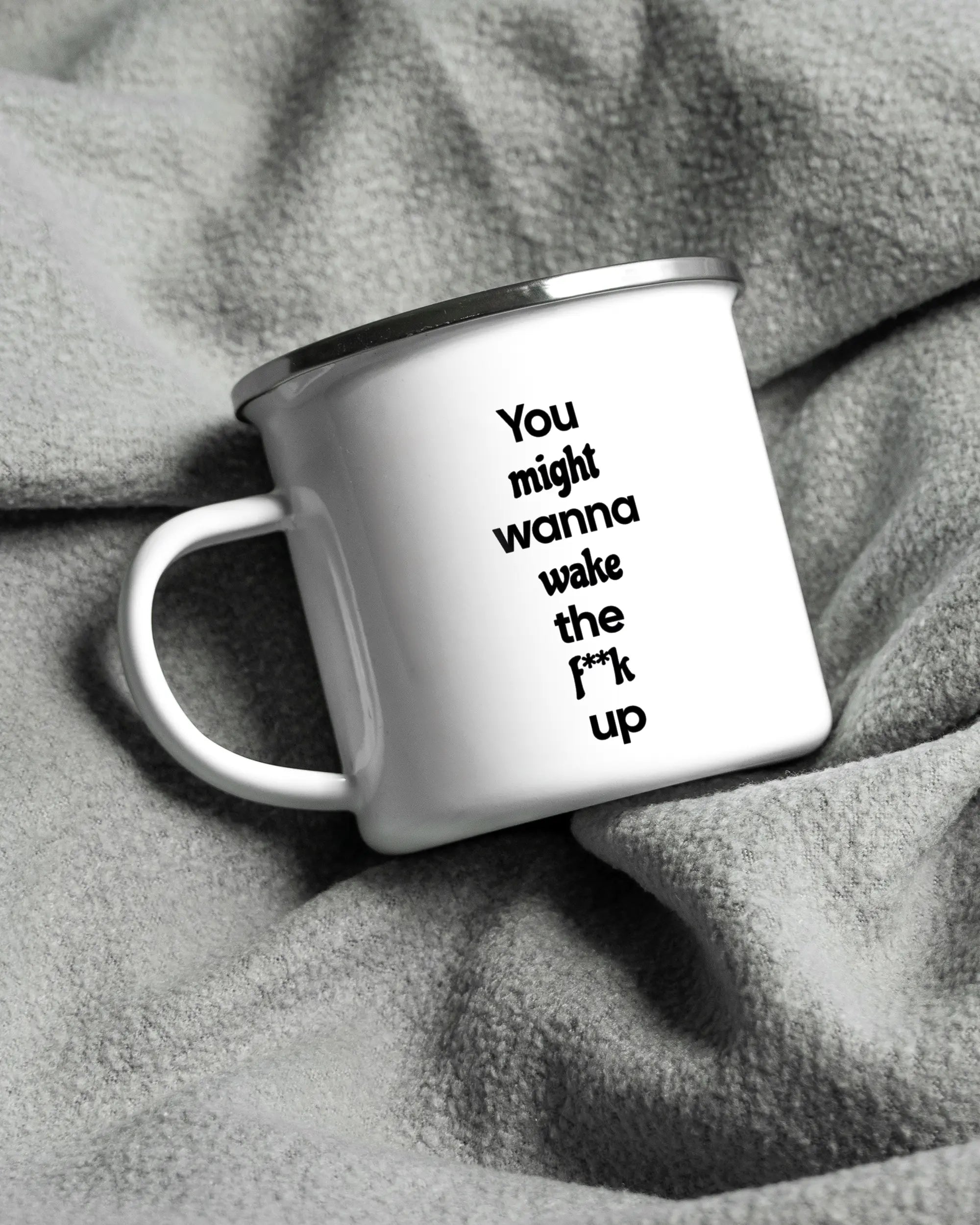 Aufnahme, die die linke Seite der beidseitig bedruckten Emailletasse von Maondo auf einer flauschigen Fließdecke mit dem Design White-Silver in der Farbe  zeigt