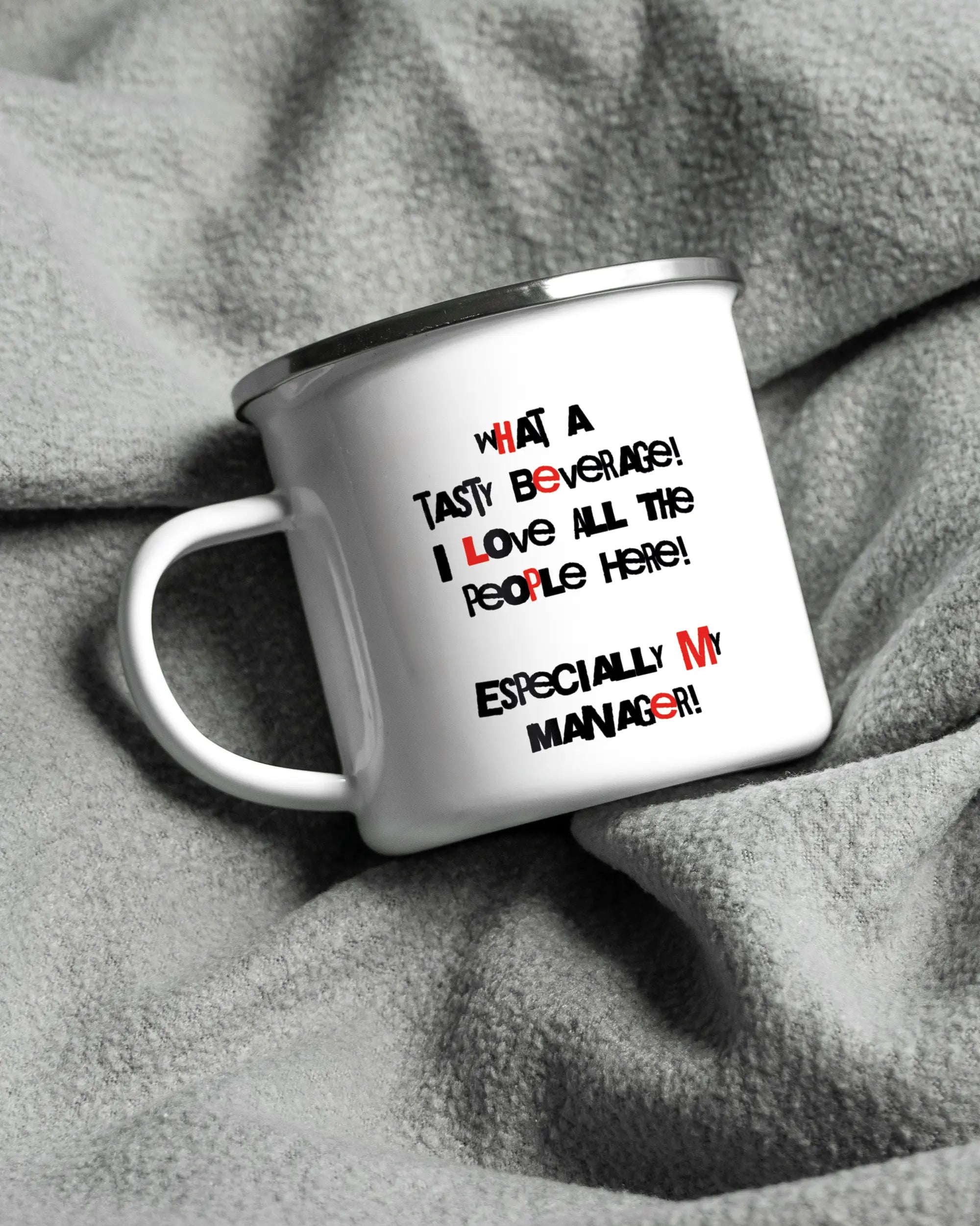 Aufnahme, die die linke Seite der beidseitig bedruckten Emailletasse von Maondo auf einer flauschigen Fließdecke mit dem Design White-Silver in der Farbe  zeigt