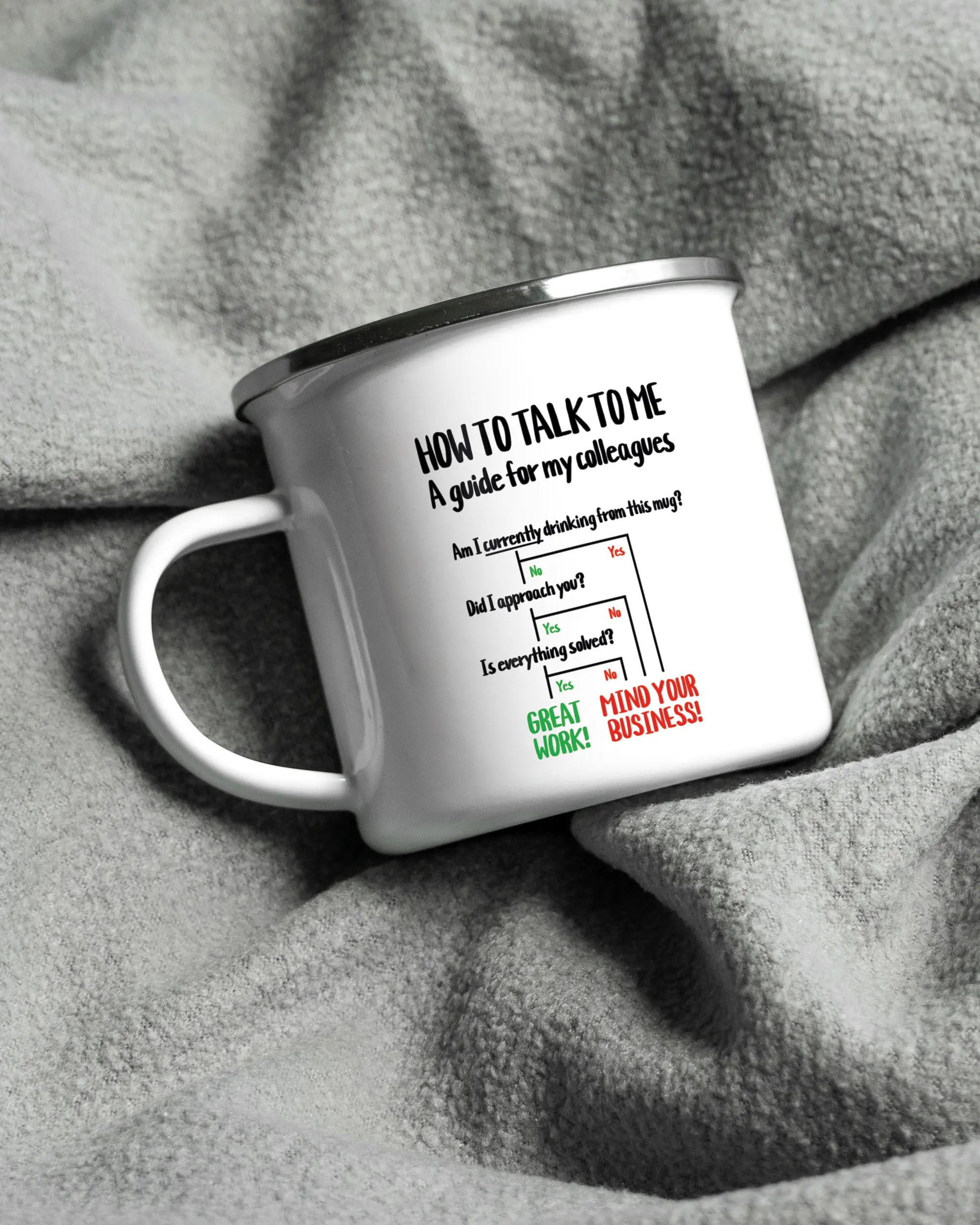 Aufnahme, die die linke Seite der beidseitig bedruckten Emailletasse von Maondo auf einer flauschigen Fließdecke mit dem Design White-Silver in der Farbe  zeigt