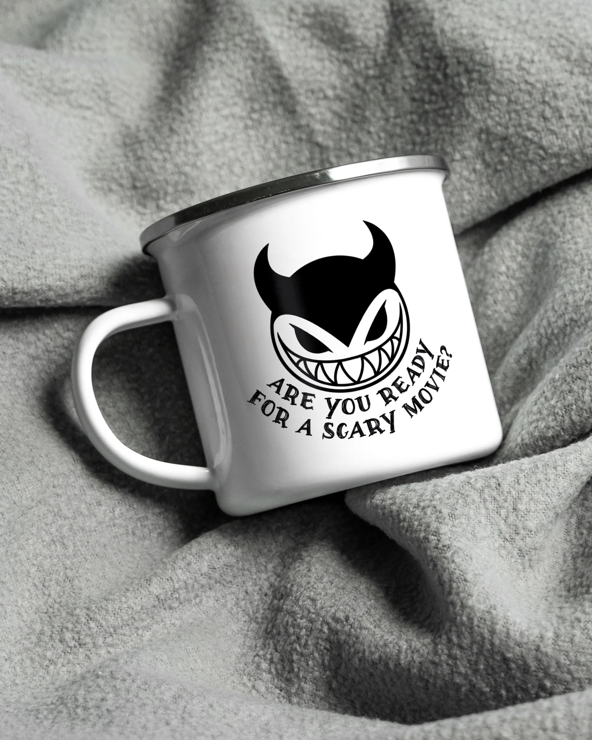 Aufnahme, die die linke Seite der beidseitig bedruckten Emailletasse von Maondo auf einer flauschigen Fließdecke mit dem Design White-Silver in der Farbe  zeigt