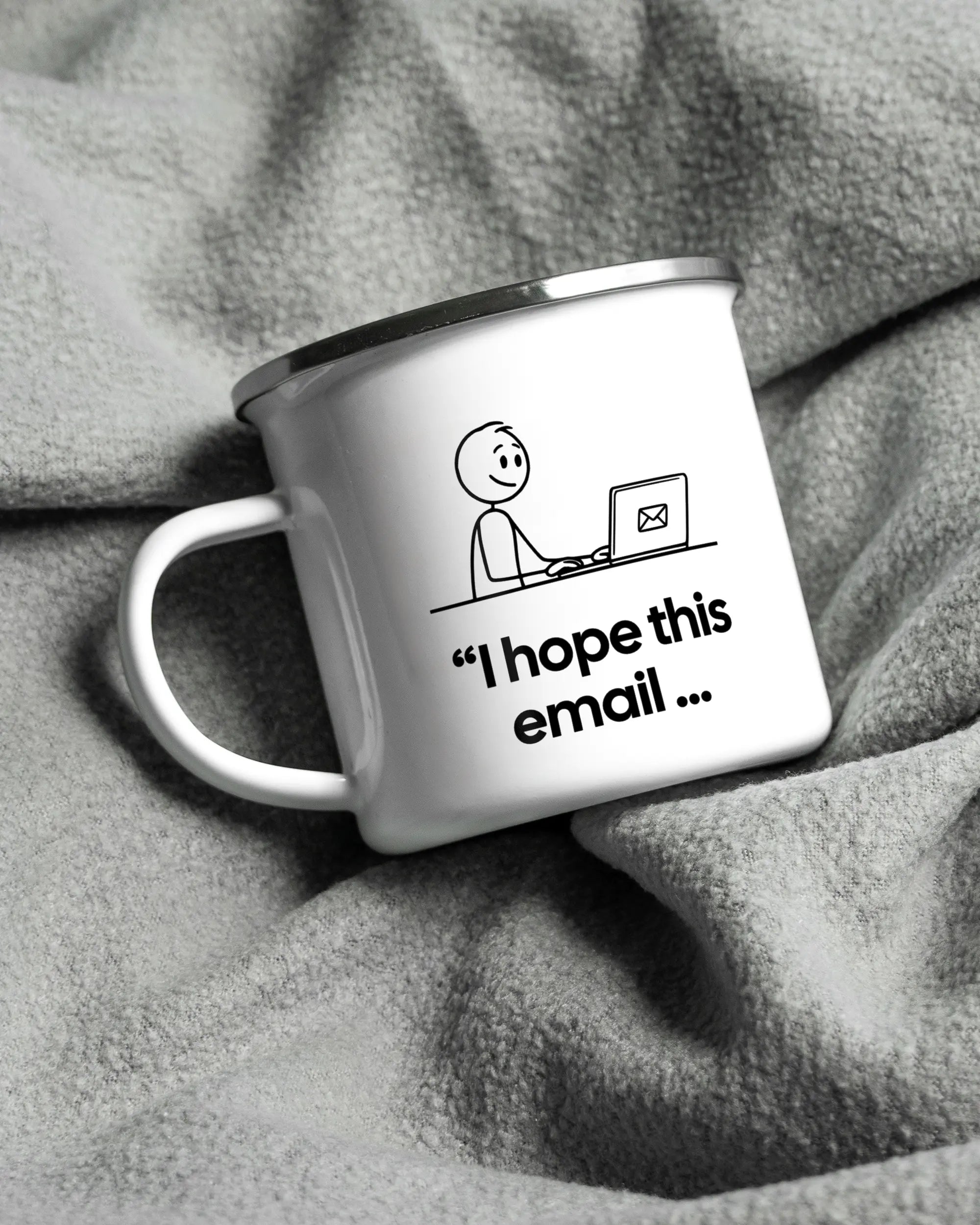 Aufnahme, die die linke Seite der beidseitig bedruckten Emailletasse von Maondo auf einer flauschigen Fließdecke mit dem Design White-Silver in der Farbe  zeigt