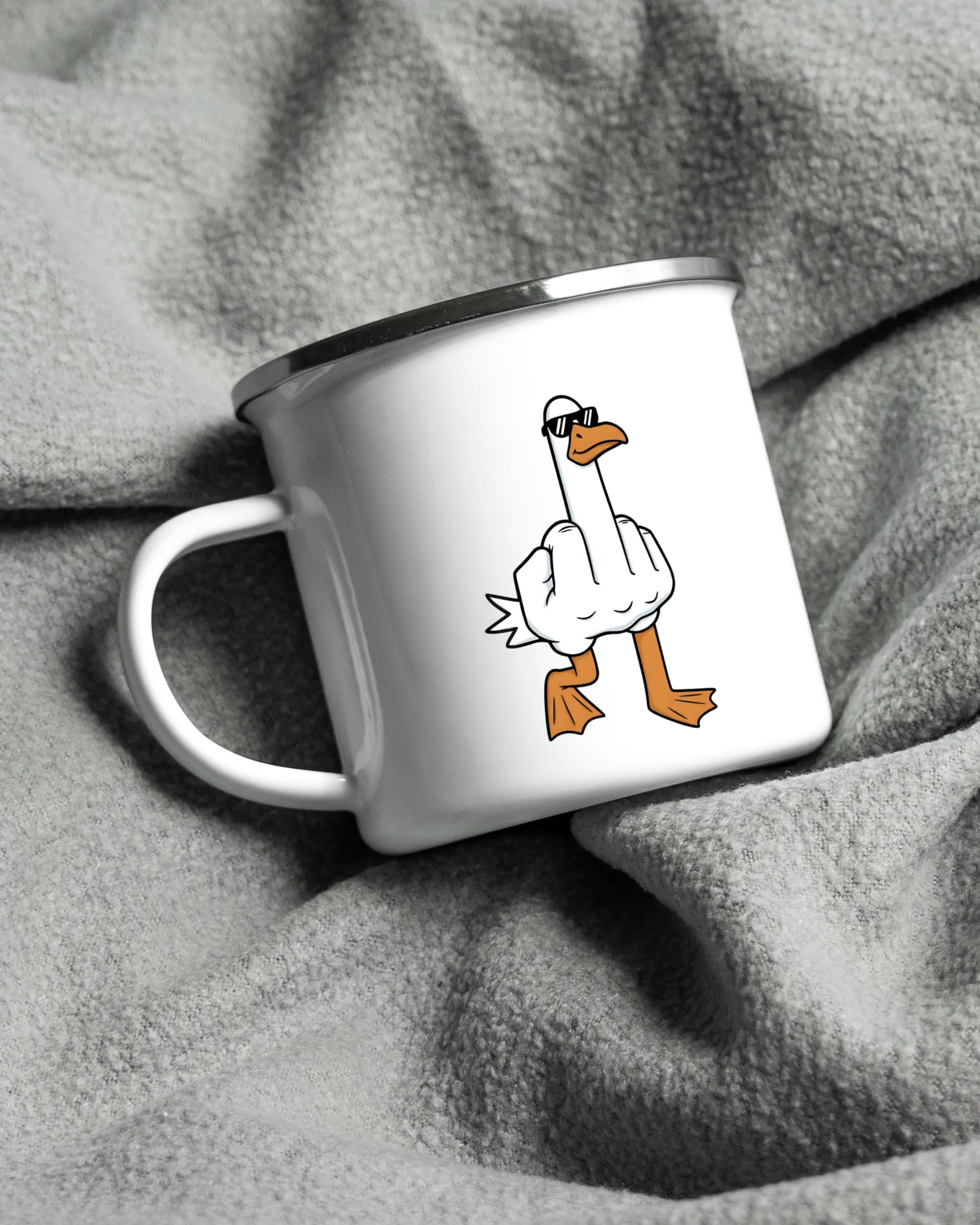 Aufnahme, die die linke Seite der beidseitig bedruckten Emailletasse von Maondo auf einer flauschigen Fließdecke mit dem Design White-Silver in der Farbe  zeigt