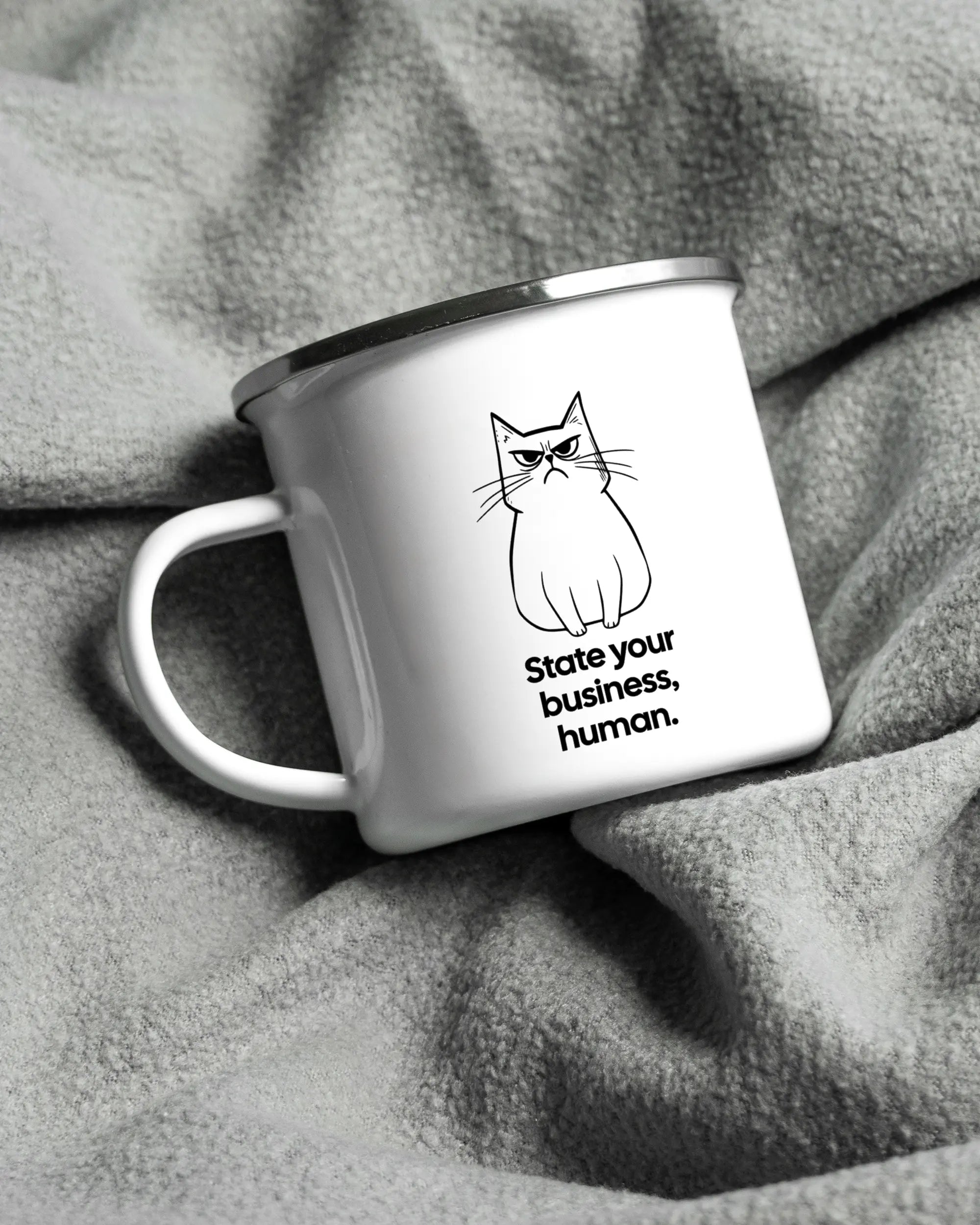 Aufnahme, die die linke Seite der beidseitig bedruckten Emailletasse von Maondo auf einer flauschigen Fließdecke mit dem Design White-Silver in der Farbe  zeigt