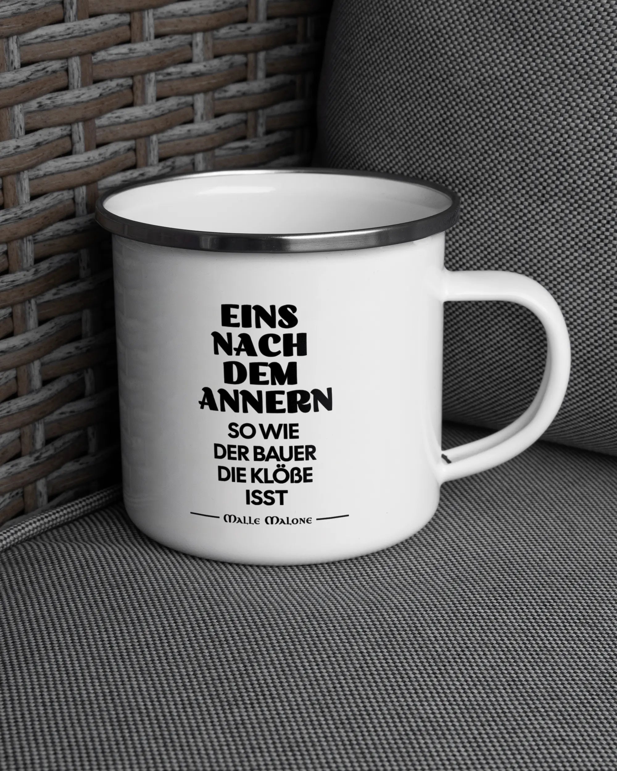 Ansicht der rechten Seite der beidseitig bedruckten Emailletasse von Maondo auf einem Balkonmöbel bzw. Campingstuhl mit dem Design White-Silver in der Farbe 