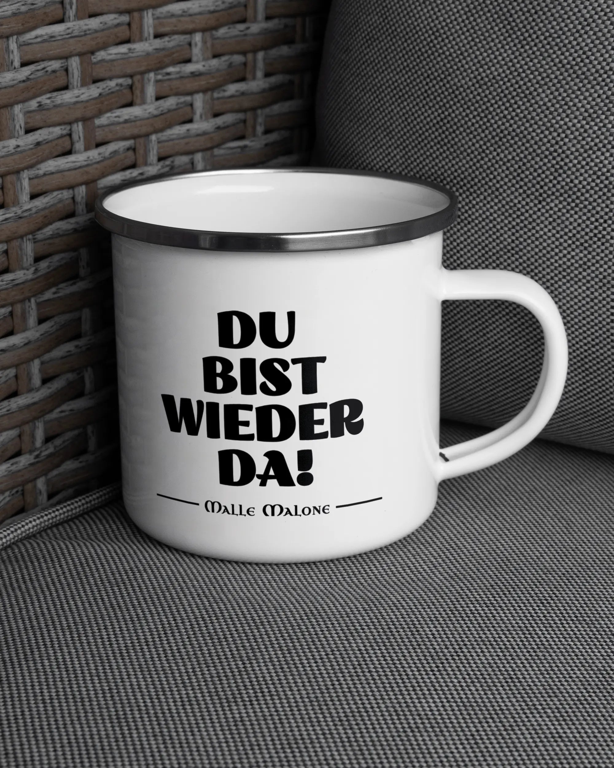 Ansicht der rechten Seite der beidseitig bedruckten Emailletasse von Maondo auf einem Balkonmöbel bzw. Campingstuhl mit dem Design White-Silver in der Farbe 
