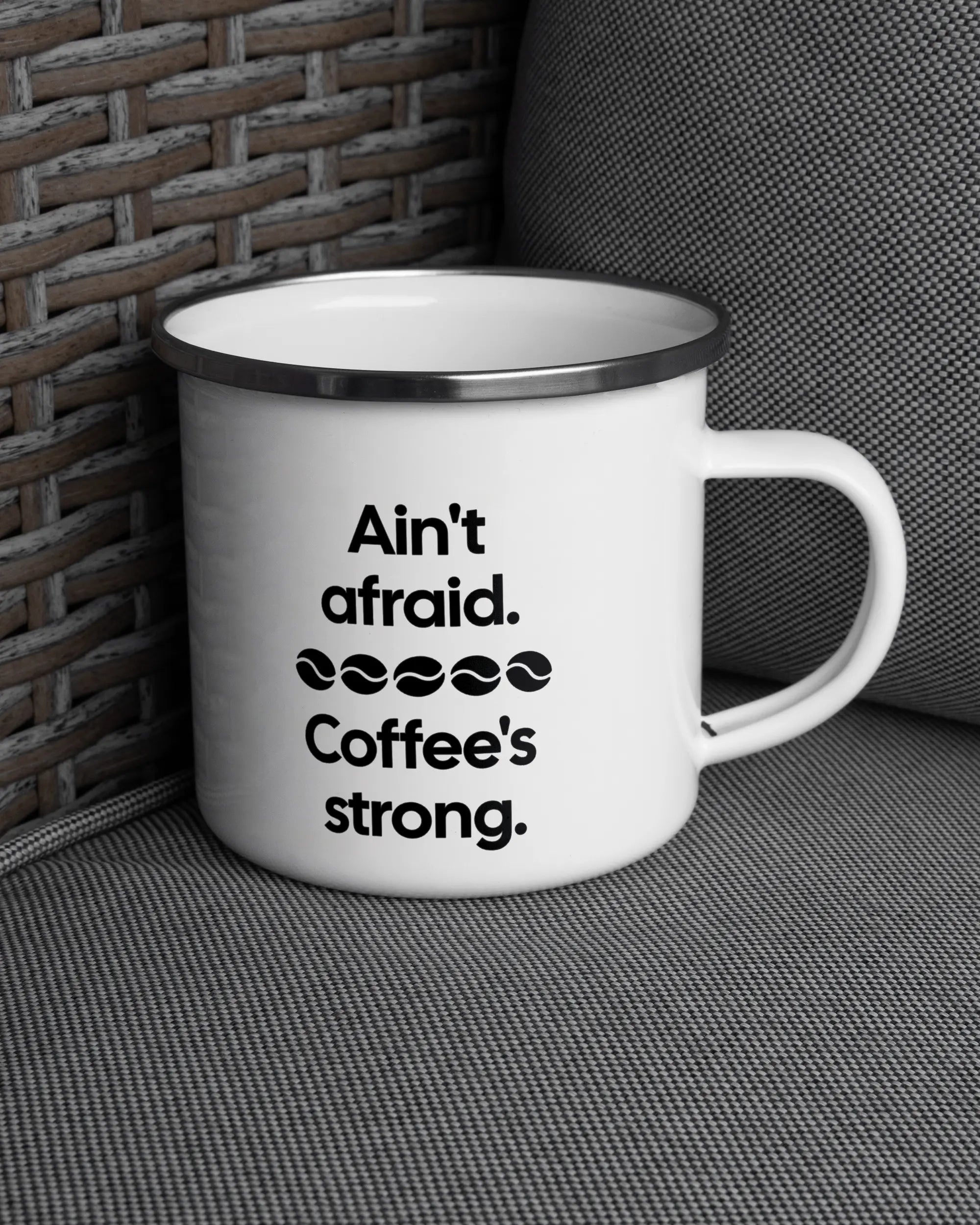 Ansicht der rechten Seite der beidseitig bedruckten Emailletasse von Maondo auf einem Balkonmöbel bzw. Campingstuhl mit dem Design White-Silver in der Farbe 