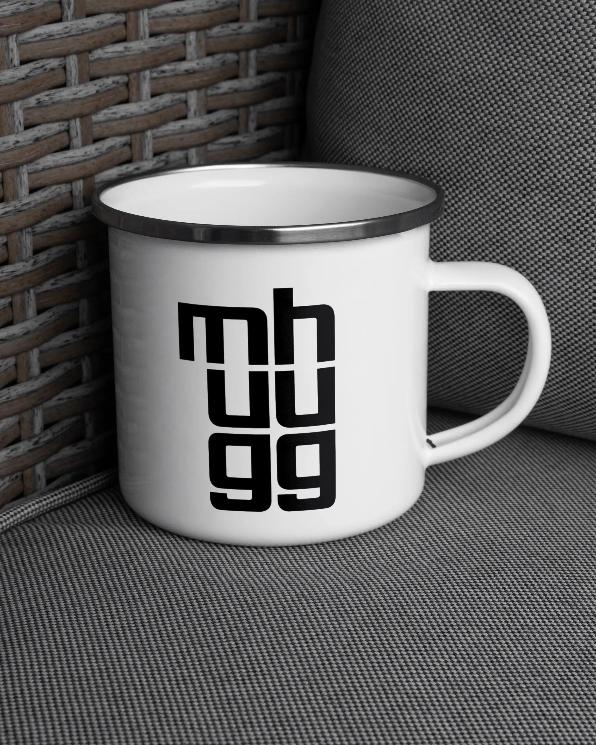 Ansicht der rechten Seite der beidseitig bedruckten Emailletasse von Maondo auf einem Balkonmöbel bzw. Campingstuhl mit dem Design White-Silver in der Farbe 