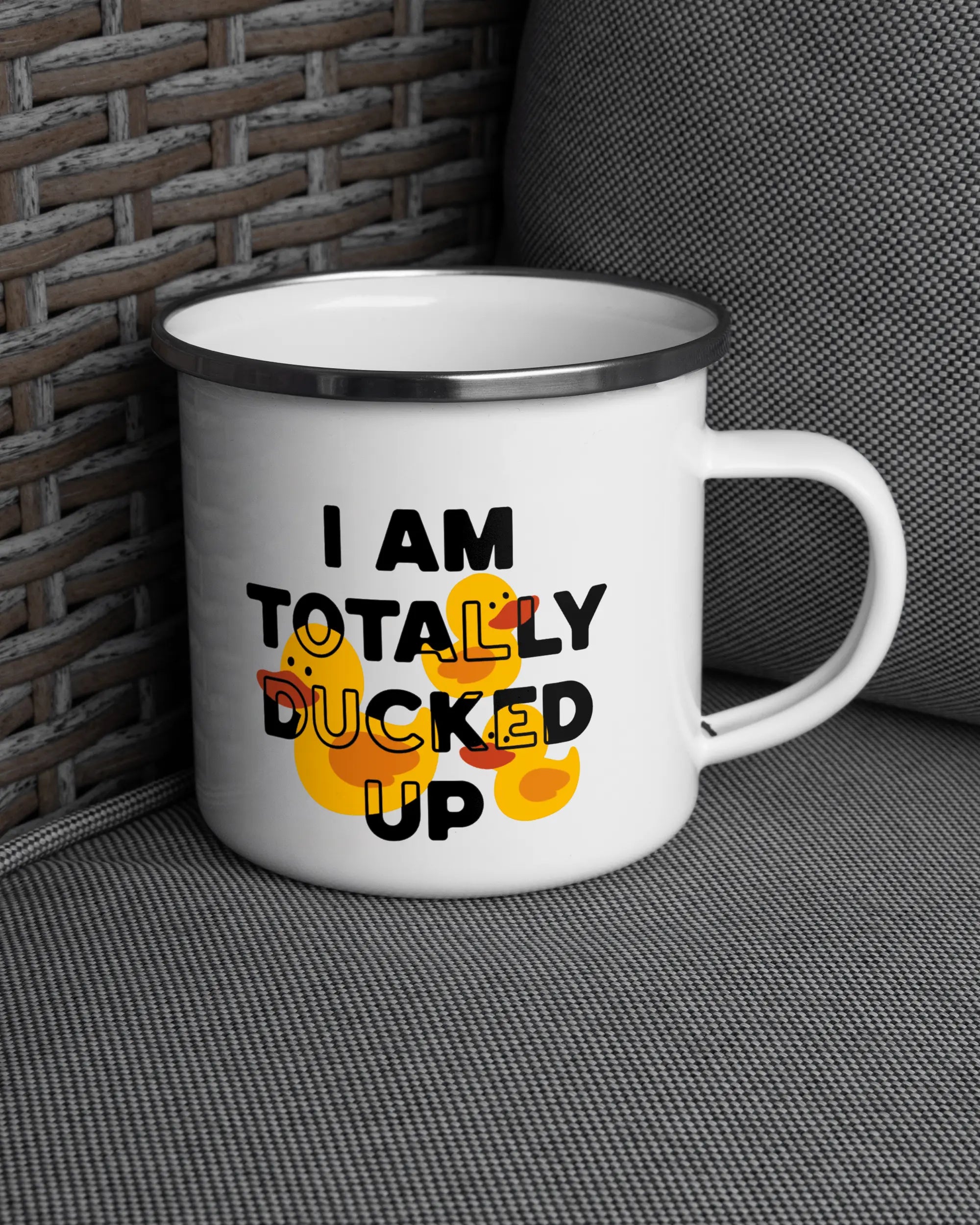 Ansicht der rechten Seite der beidseitig bedruckten Emailletasse von Maondo auf einem Balkonmöbel bzw. Campingstuhl mit dem Design White-Silver in der Farbe 