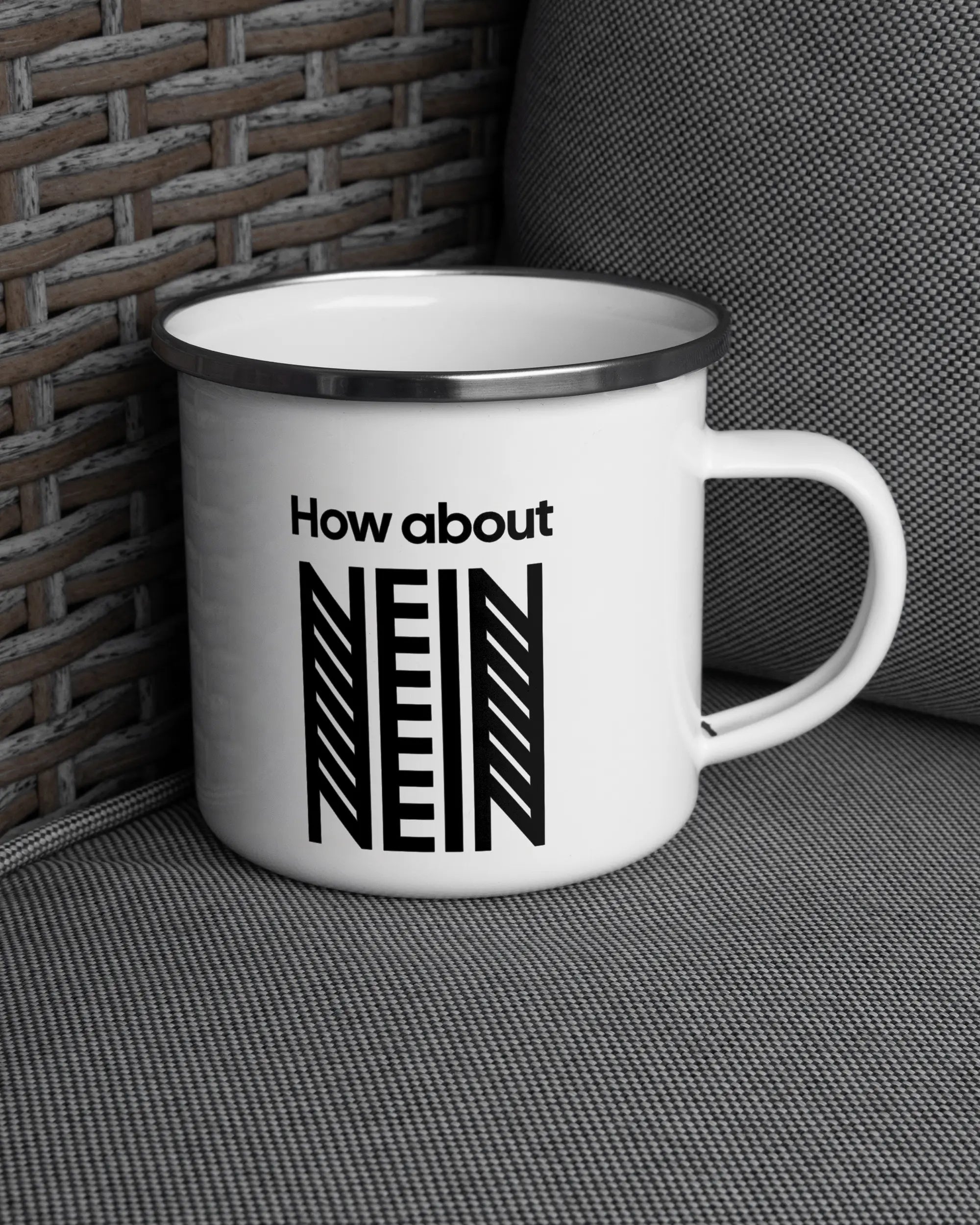 Ansicht der rechten Seite der beidseitig bedruckten Emailletasse von Maondo auf einem Balkonmöbel bzw. Campingstuhl mit dem Design White-Silver in der Farbe 