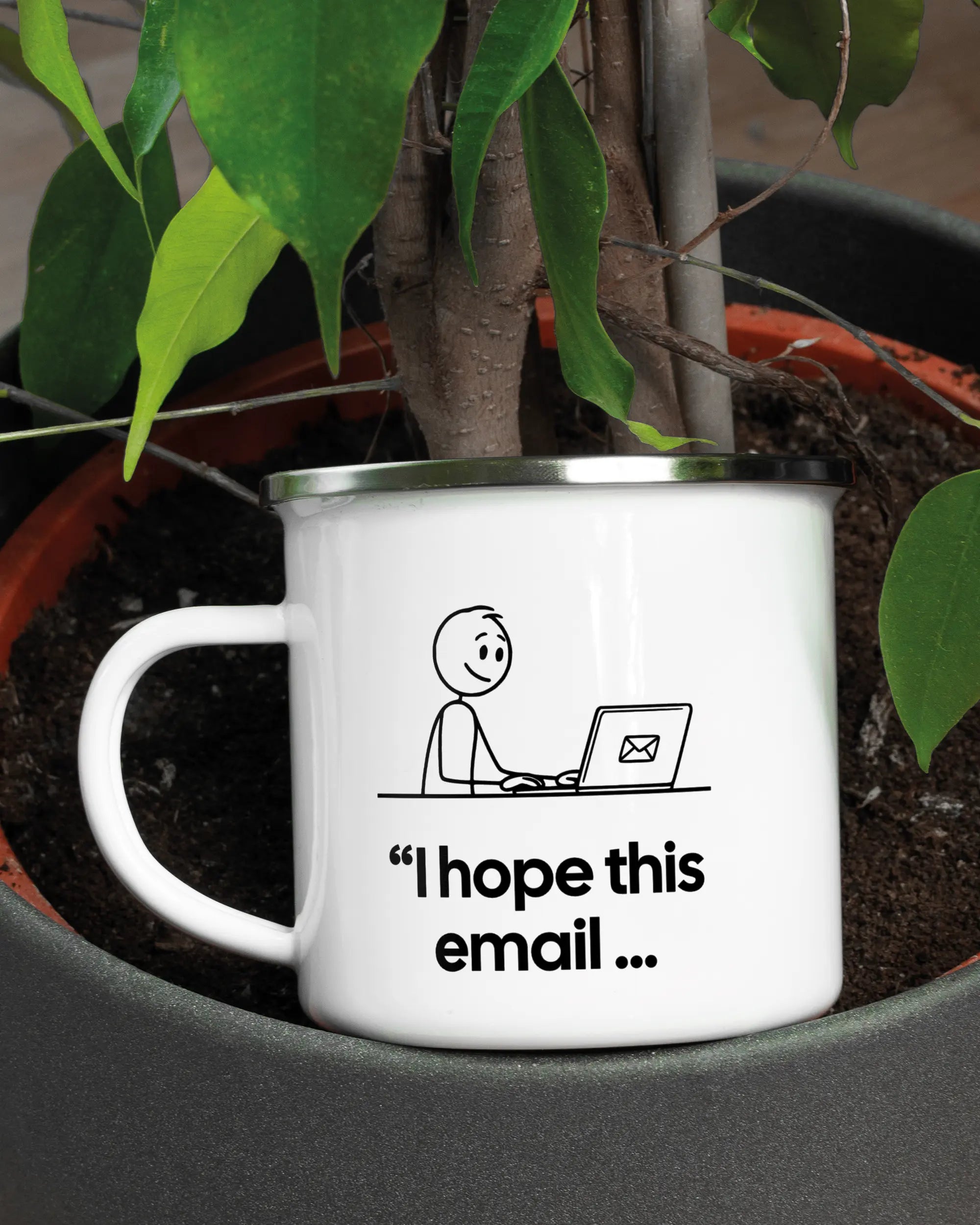 Aufnahme der linken Seite der beidseitig bedruckten Emailletasse von Maondo mit dem Design Found me not well in der Farbe White-Silver in einem Blumentopf