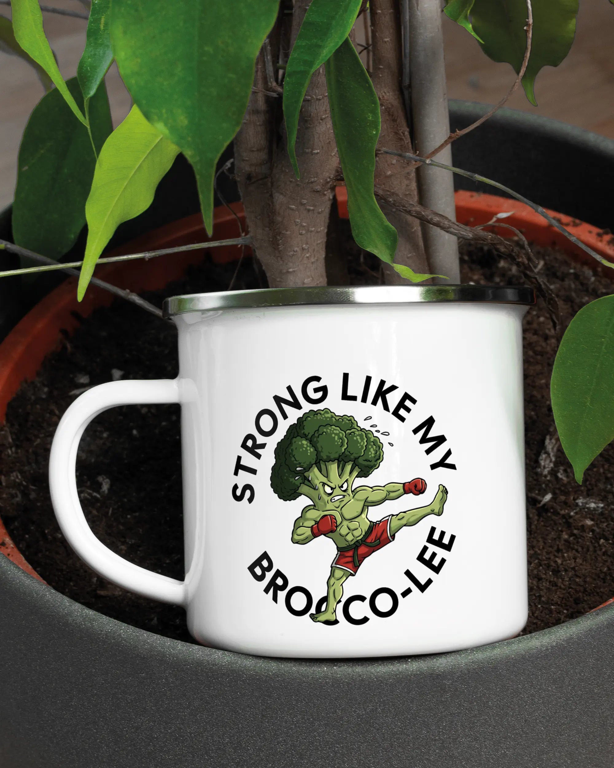 Aufnahme der linken Seite der beidseitig bedruckten Emailletasse von Maondo mit dem Design Brocco-Lee in der Farbe White-Silver in einem Blumentopf