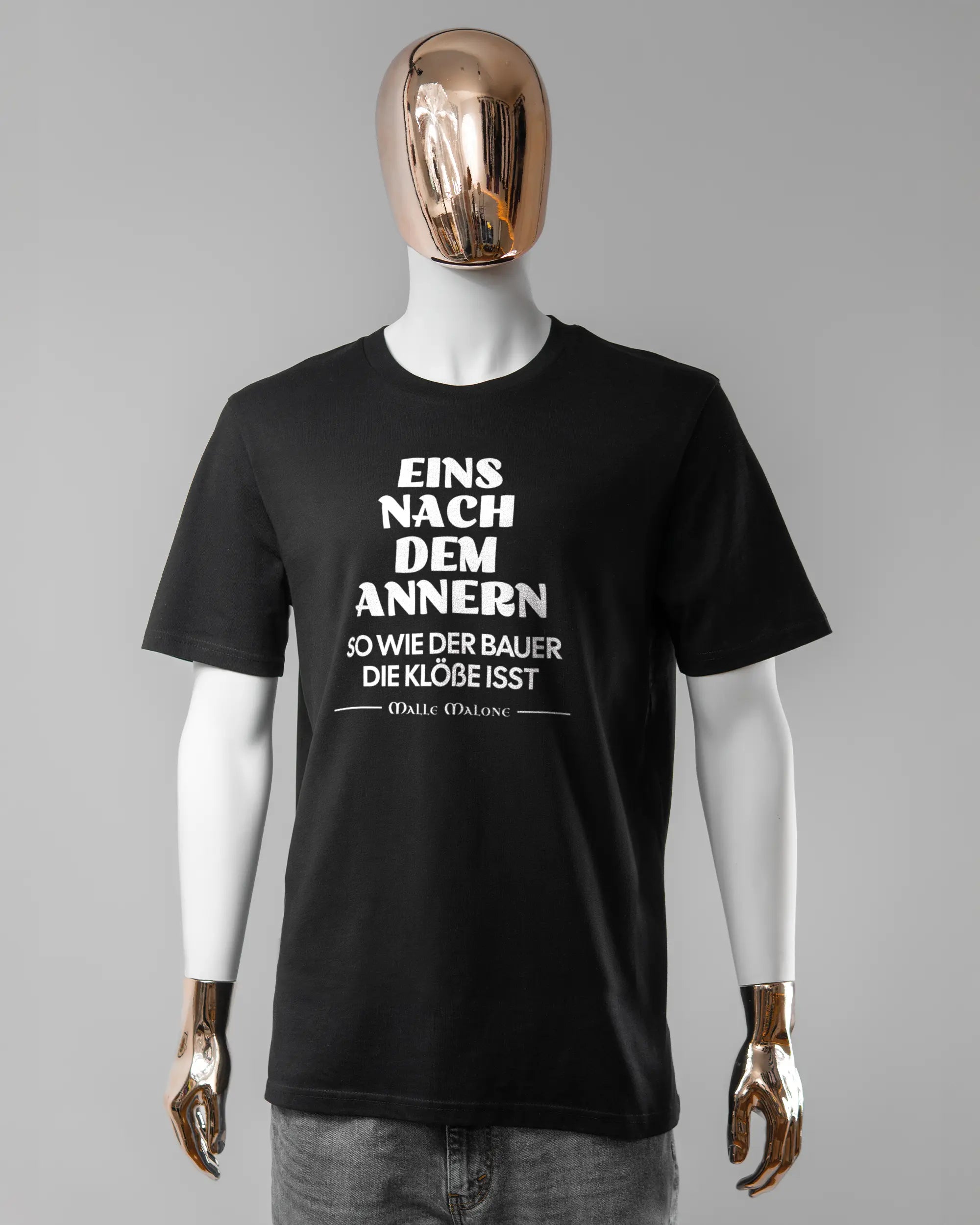 Vorderseite des Organic Unisex T-Shirt Casual von Maondo mit dem Design Eins nach dem Annern in der Farbe Black und in der Größe L getragen von einer maskulinen Puppe