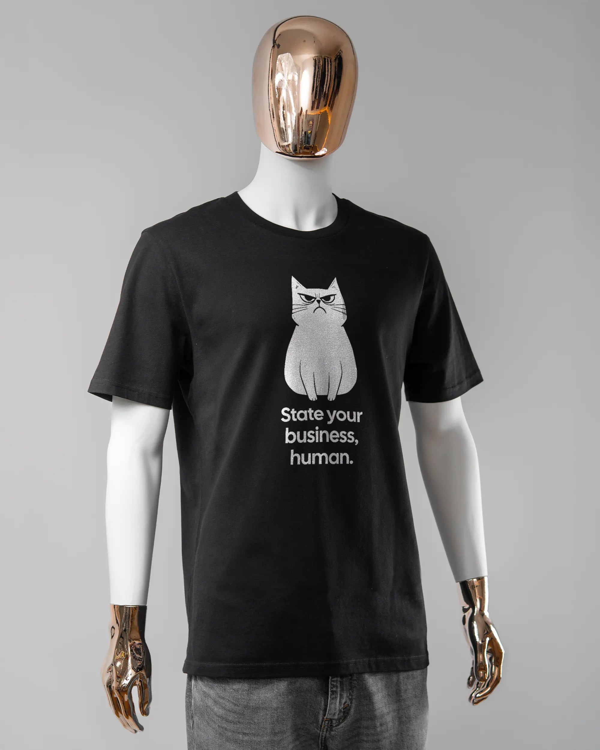 Vorderseite des Organic Unisex T-Shirt Casual von Maondo mit dem Design Grumpy Purr in der Farbe Black und in der Größe L getragen von einer maskulinen Puppe