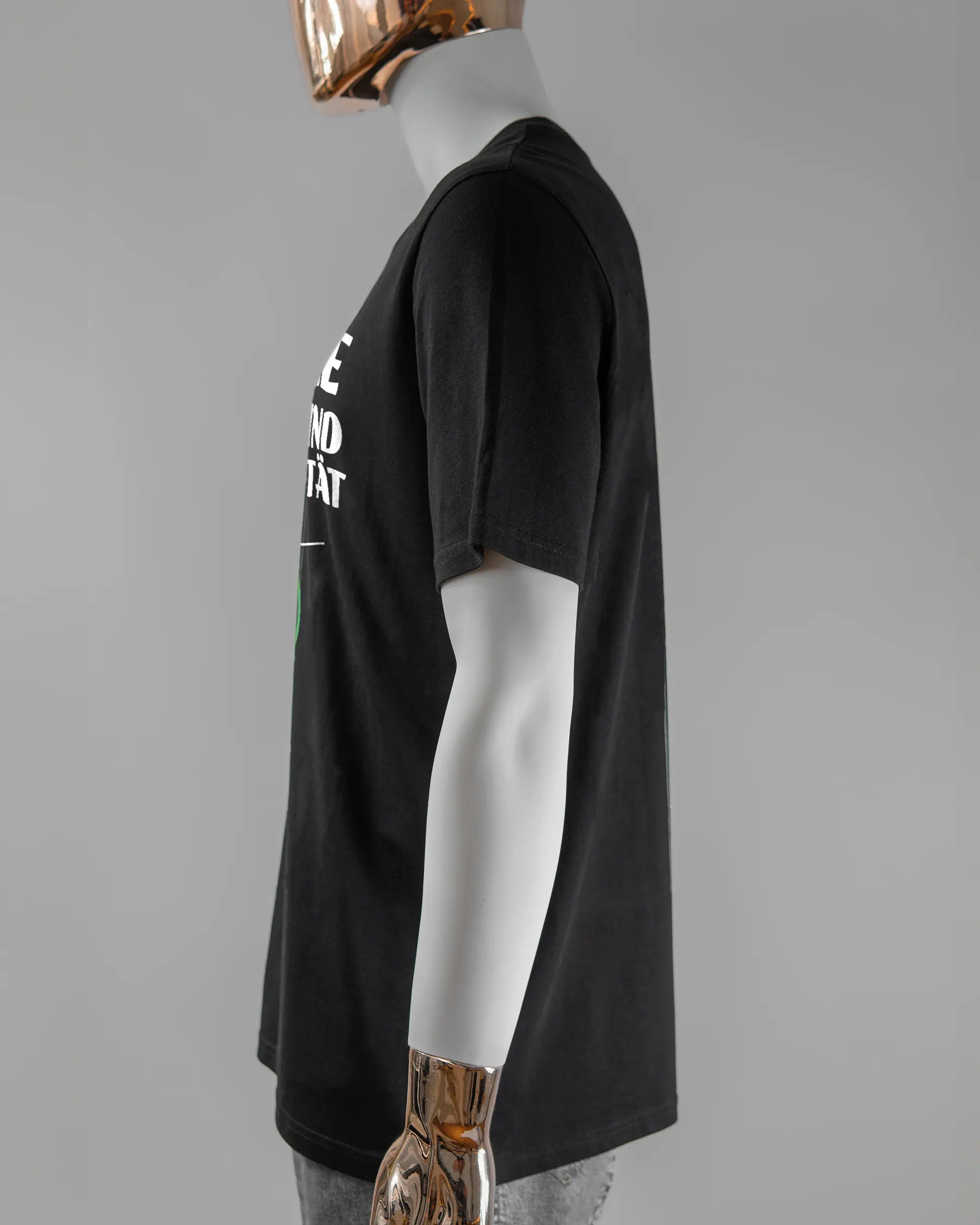 Seitenansicht des Organic Unisex T-Shirt Casual von Maondo mit dem Design Keine Eile vorne in der Farbe Black und in der Größe L getragen von einer maskulinen Puppe