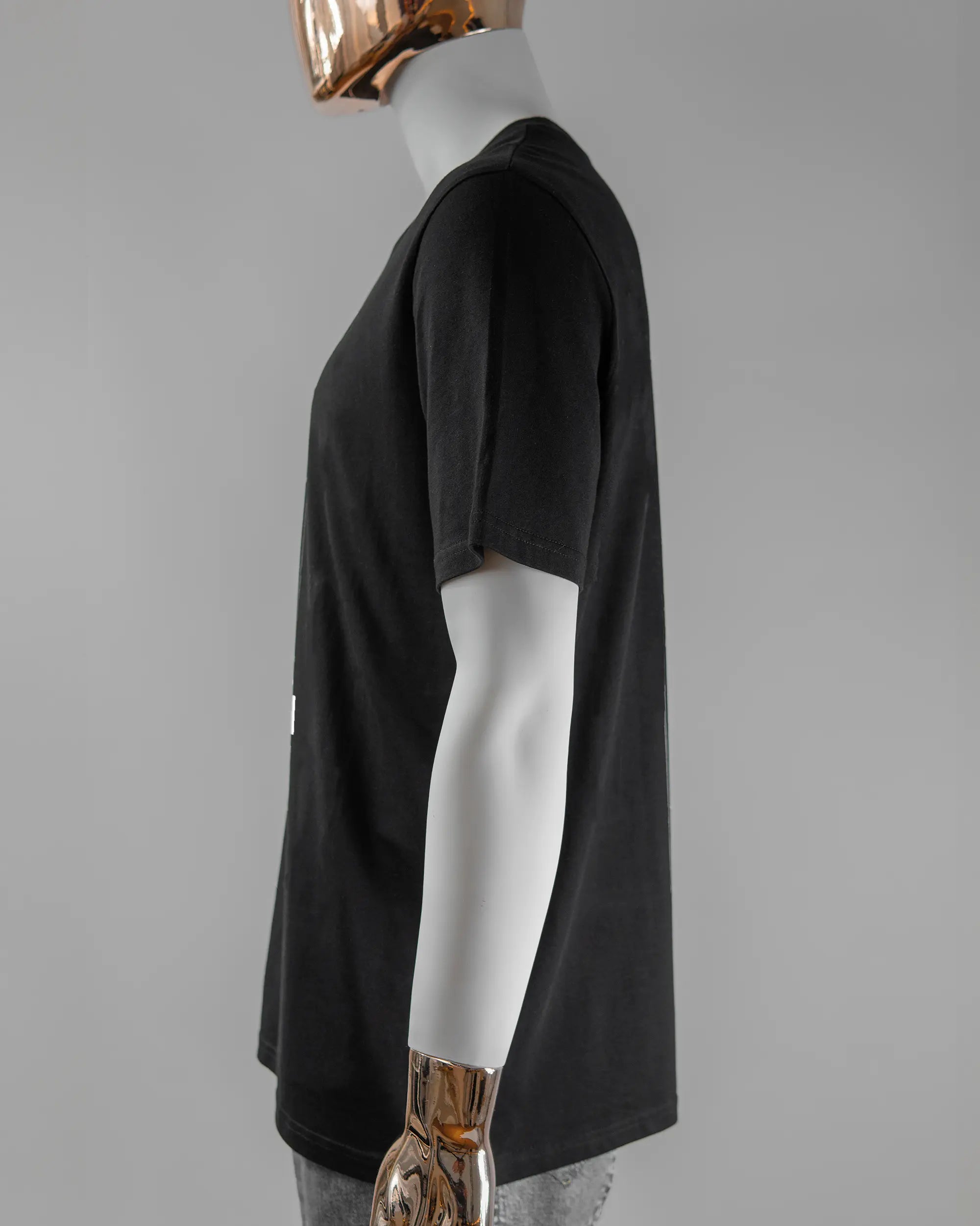 Seitenansicht des Organic Unisex T-Shirt Casual von Maondo mit dem Design Pigeon Pun vorne in der Farbe Black und in der Größe L getragen von einer maskulinen Puppe