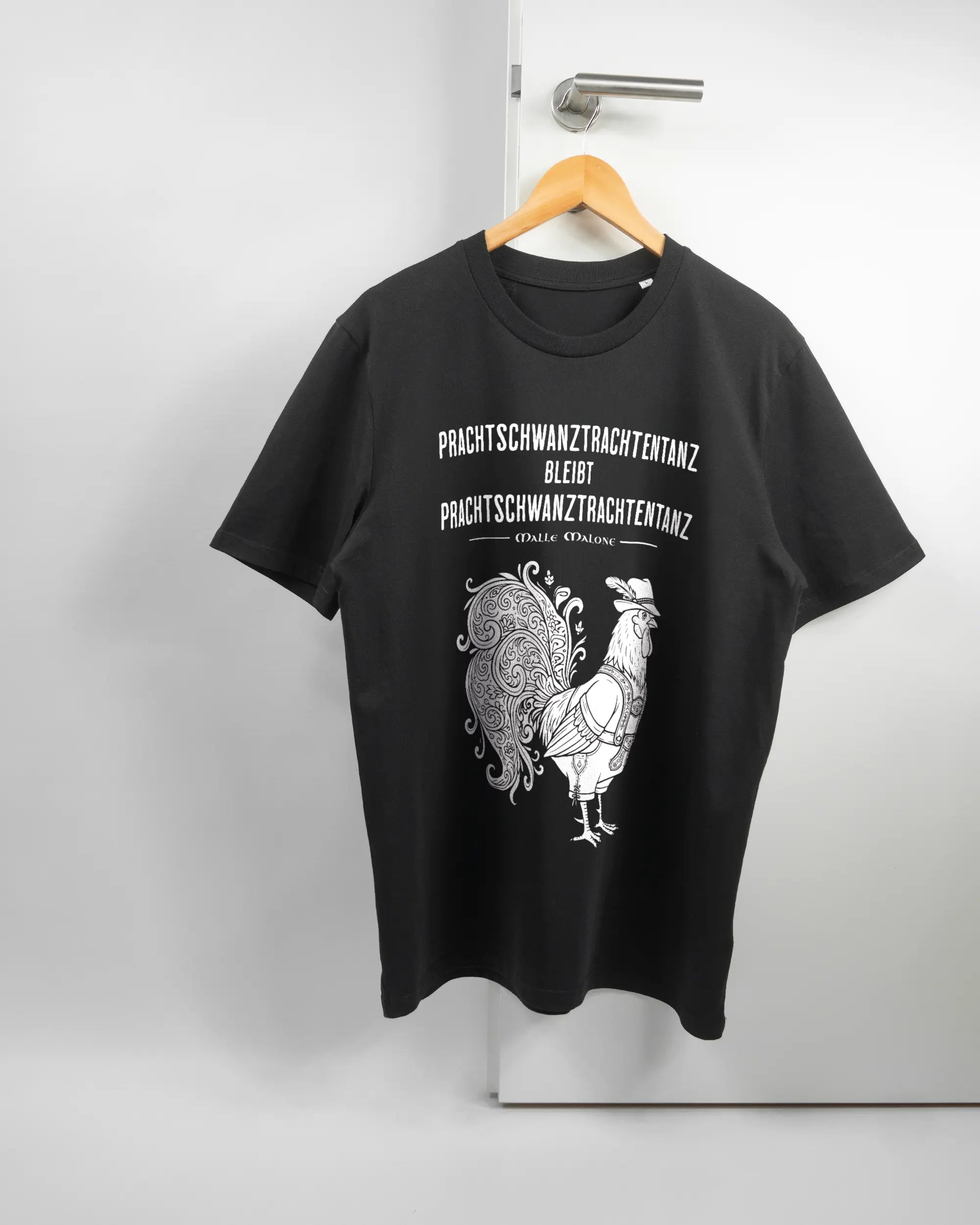 Vorderseite des Organic Unisex T-Shirt Casual von Maondo mit dem Design Trachtentanz in der Farbe Black und in der Größe L auf einem Bügel an der Türklinke aufgehängt