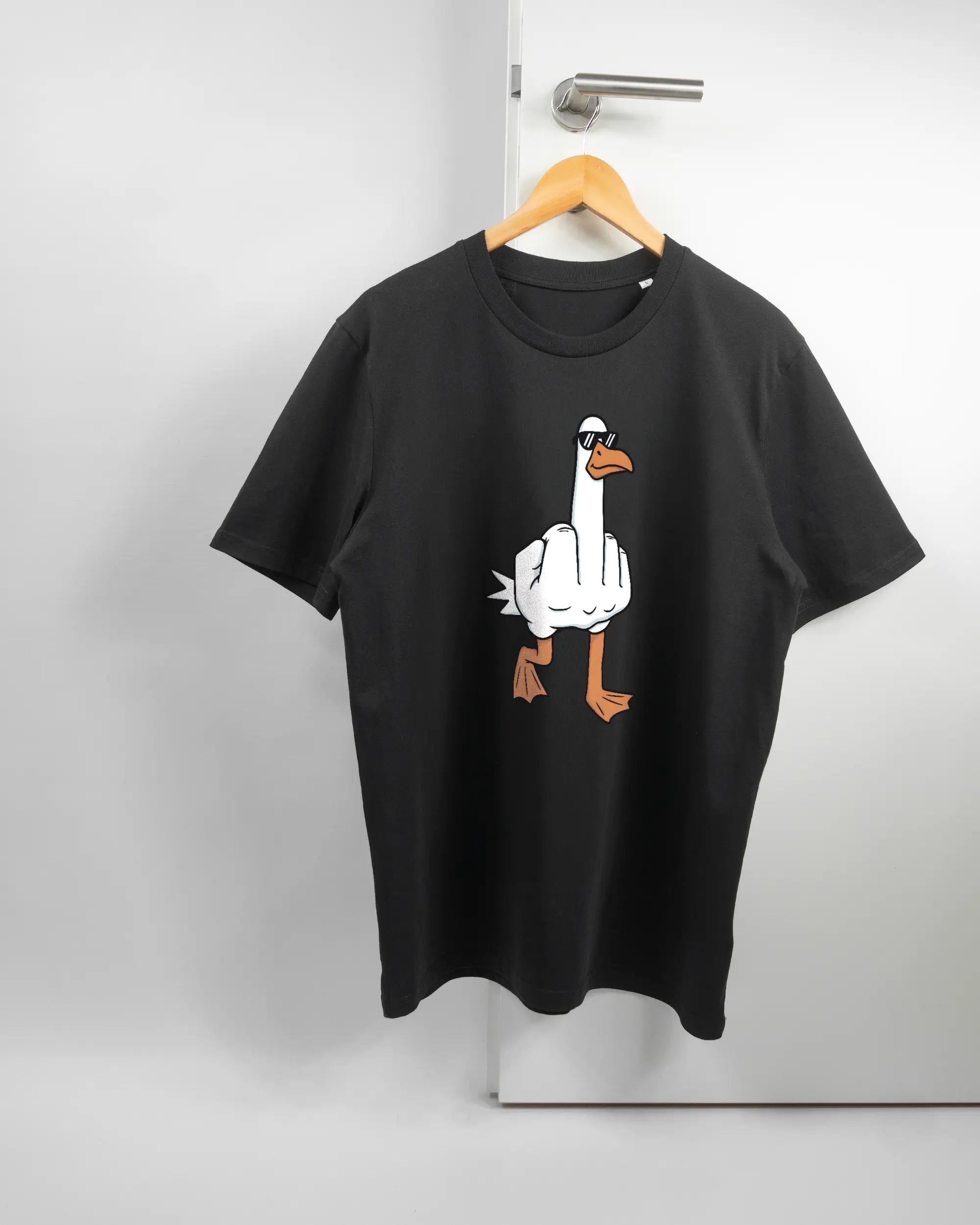Vorderseite des Organic Unisex T-Shirt Casual von Maondo mit dem Design I give a duck in der Farbe Black und in der Größe L auf einem Bügel an der Türklinke aufgehängt