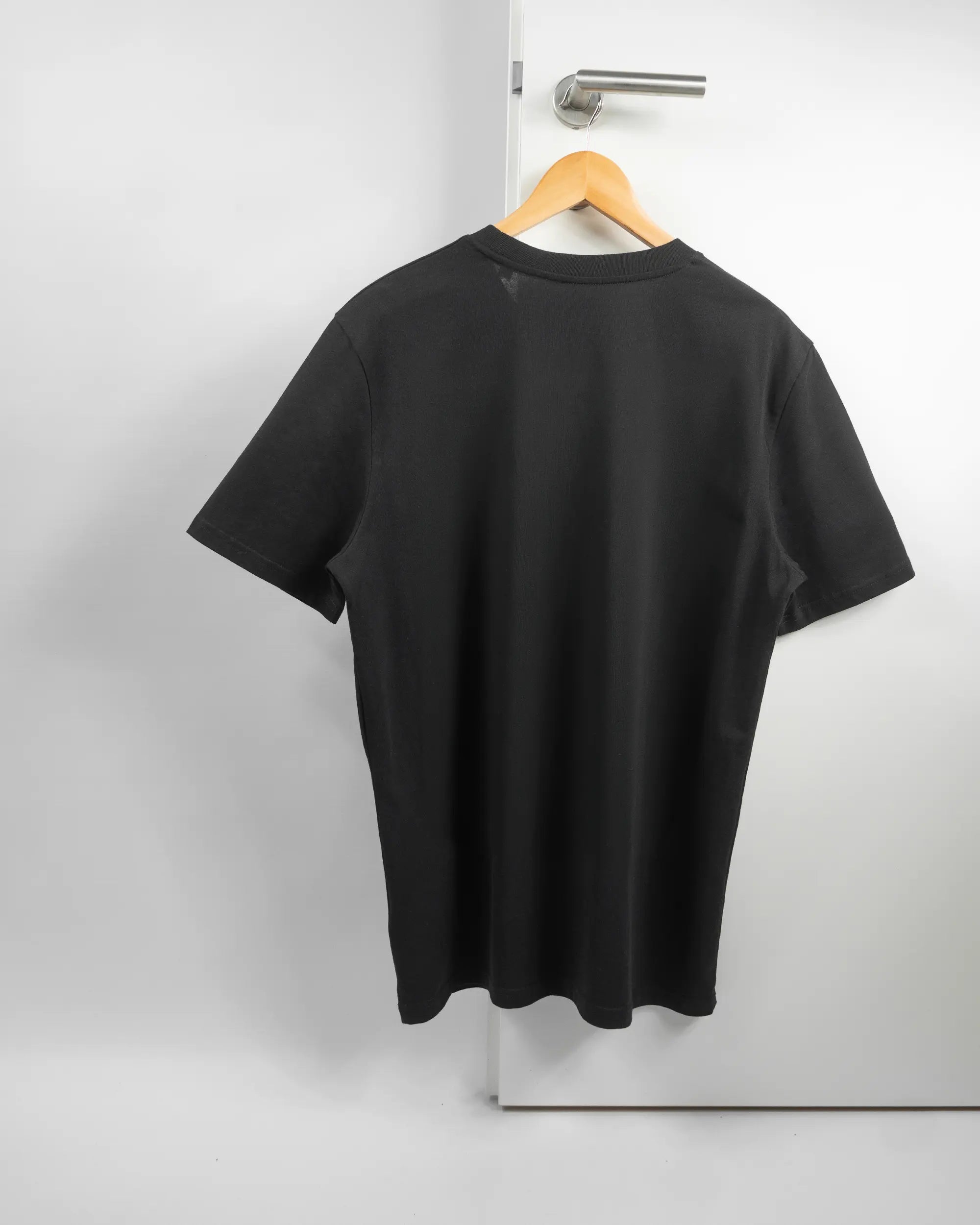 Rückseite des Organic Unisex T-Shirt Casual von Maondo ohne Motiv in der Farbe Black und in der Größe L auf einem Bügel an der Türklinke aufgehängt