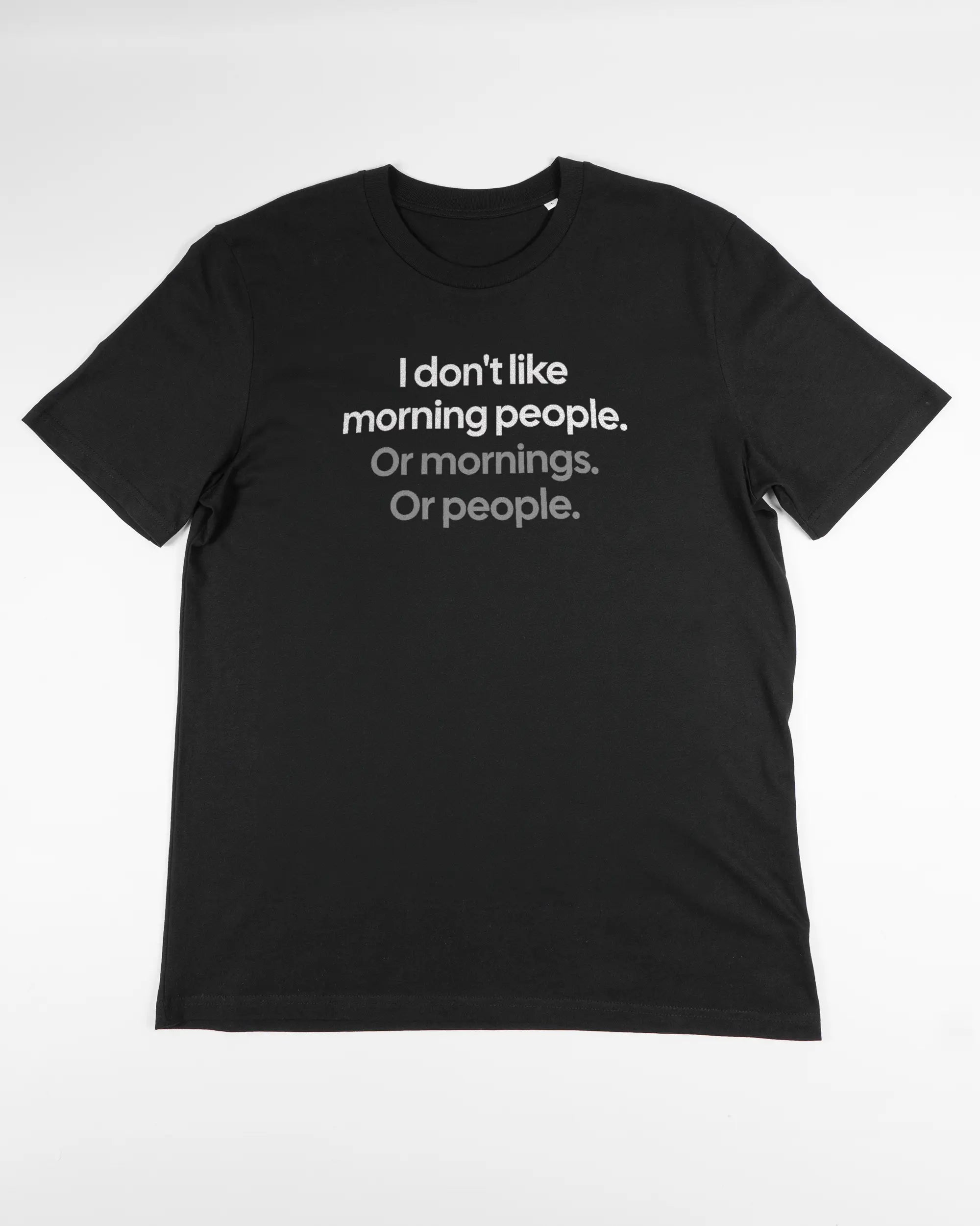 Vorderseite des Organic Unisex T-Shirt Casual von Maondo mit dem Design Morning Person in der Farbe Black und in der Größe L flach auf den Boden gelegt