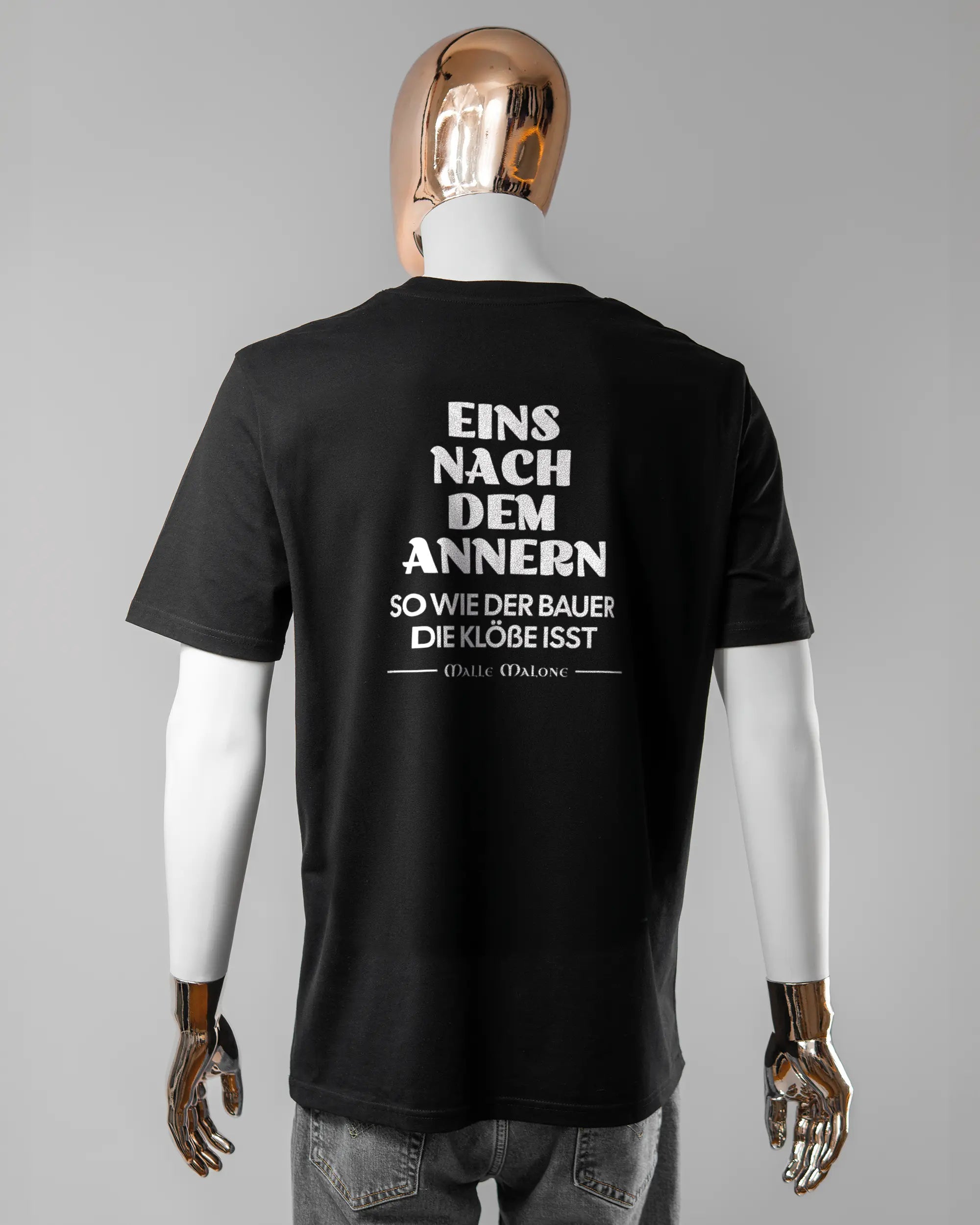 Rückseite des Organic Unisex T-Shirt Casual von Maondo mit dem Design Eins nach dem Annern in der Farbe Black und in der Größe L getragen von einer maskulinen Puppe