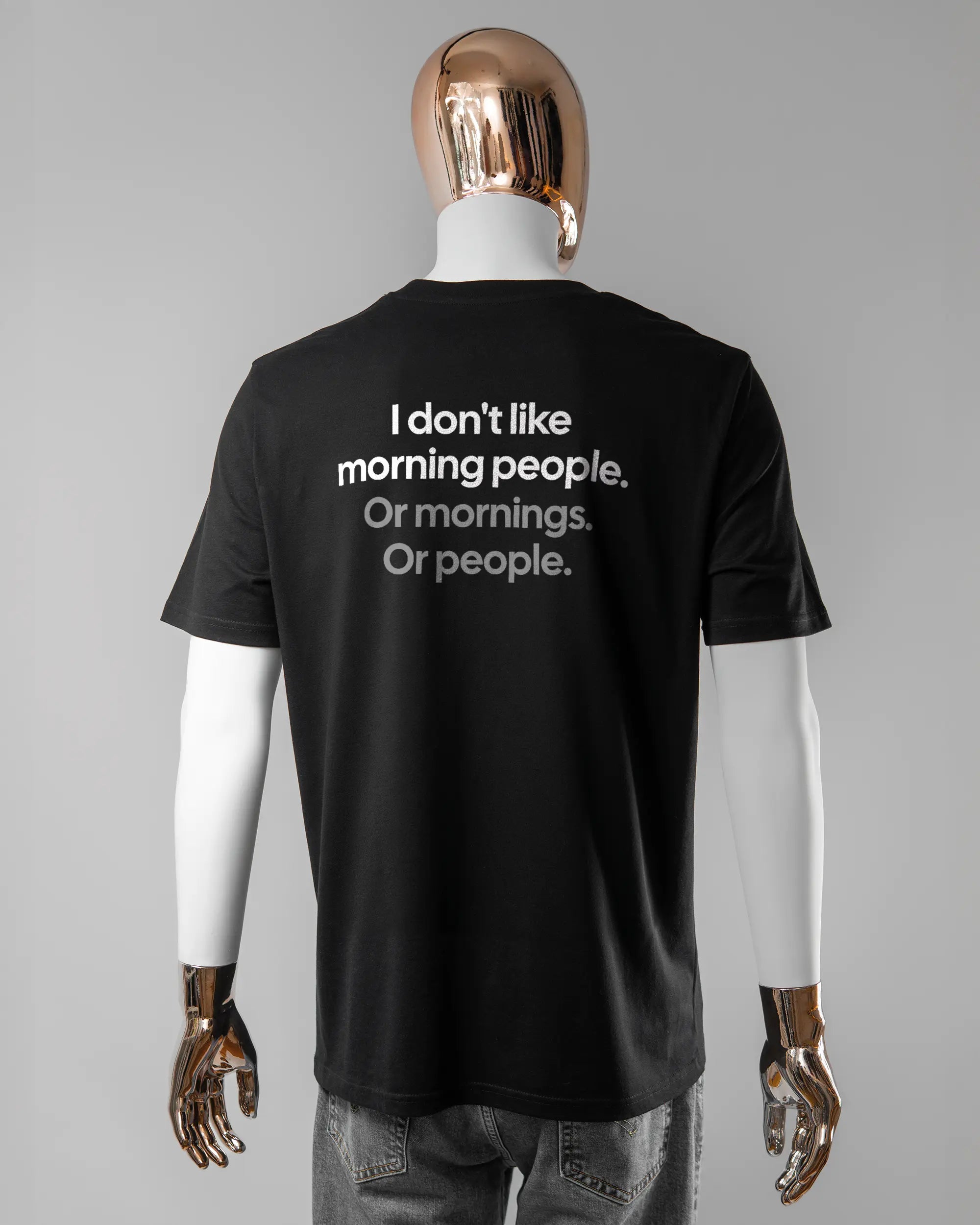 Rückseite des Organic Unisex T-Shirt Casual von Maondo mit dem Design Morning Person in der Farbe Black und in der Größe L getragen von einer maskulinen Puppe