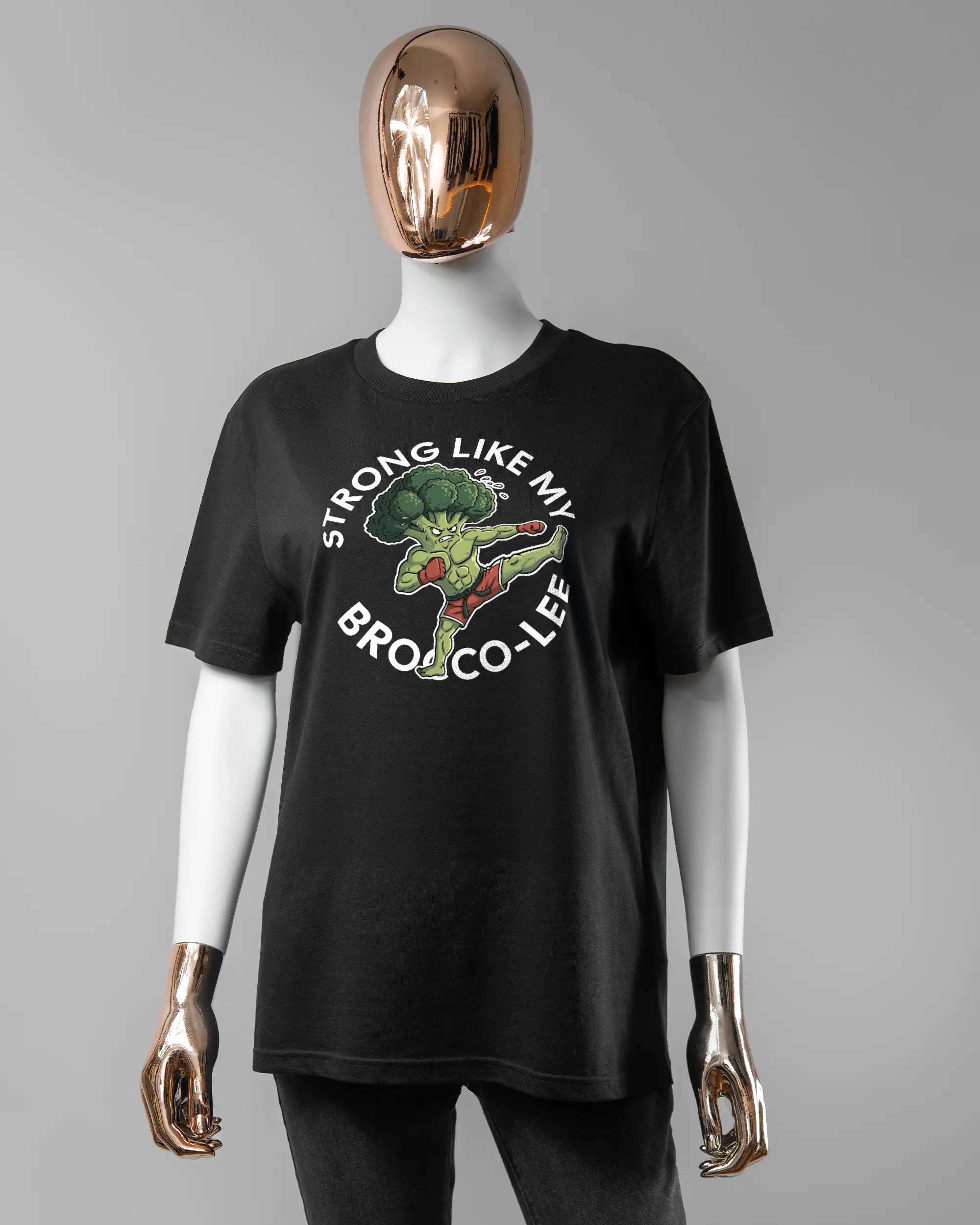 Vorderseite des Organic Unisex T-Shirt Casual von Maondo mit dem Design Brocco-Lee in der Farbe Black und in der Größe S getragen von einer femininen Puppe