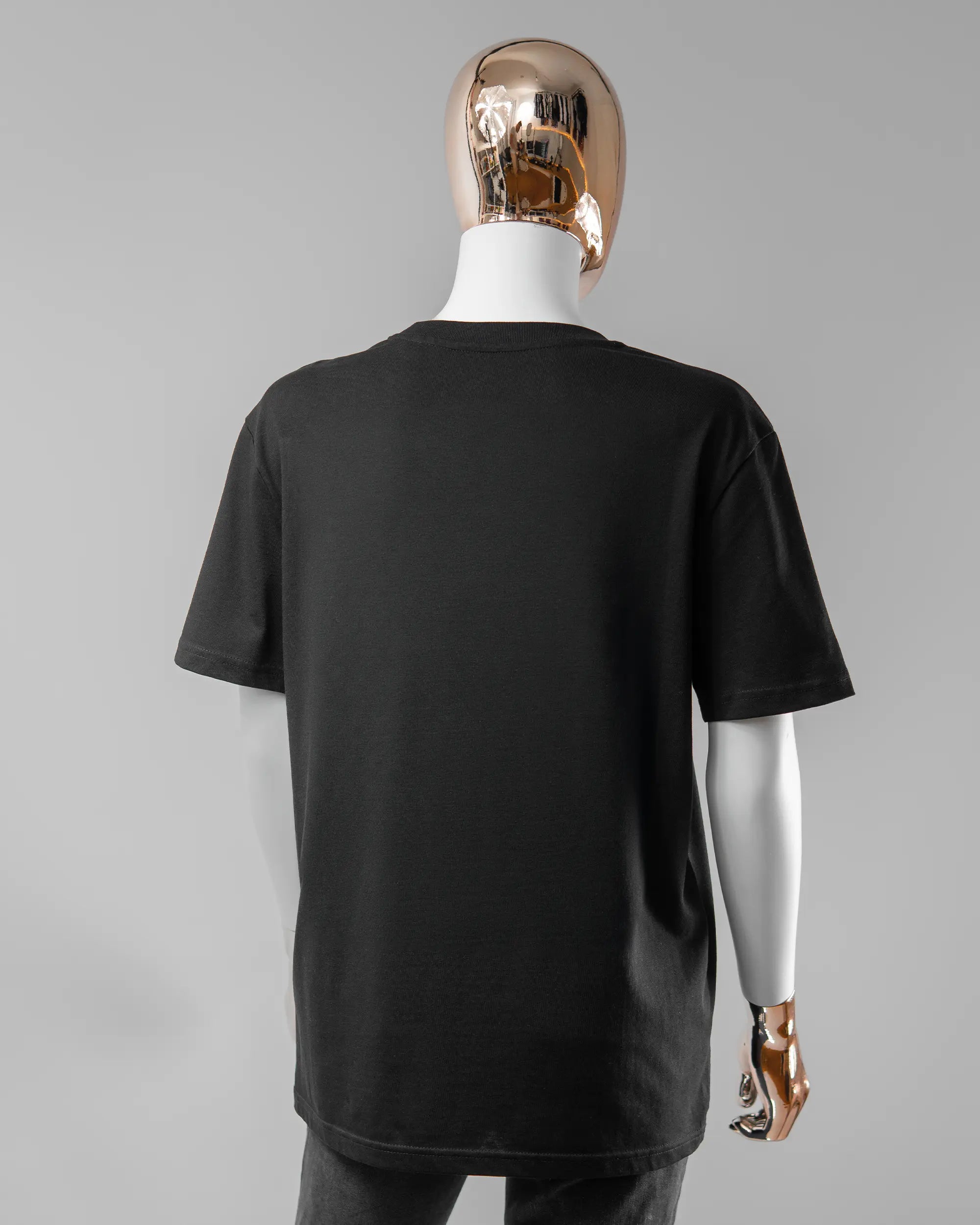 Rückseite des Organic Unisex T-Shirt Casual von Maondo ohne Motiv in der Farbe Black und in der Größe S getragen von einer femininen Puppe