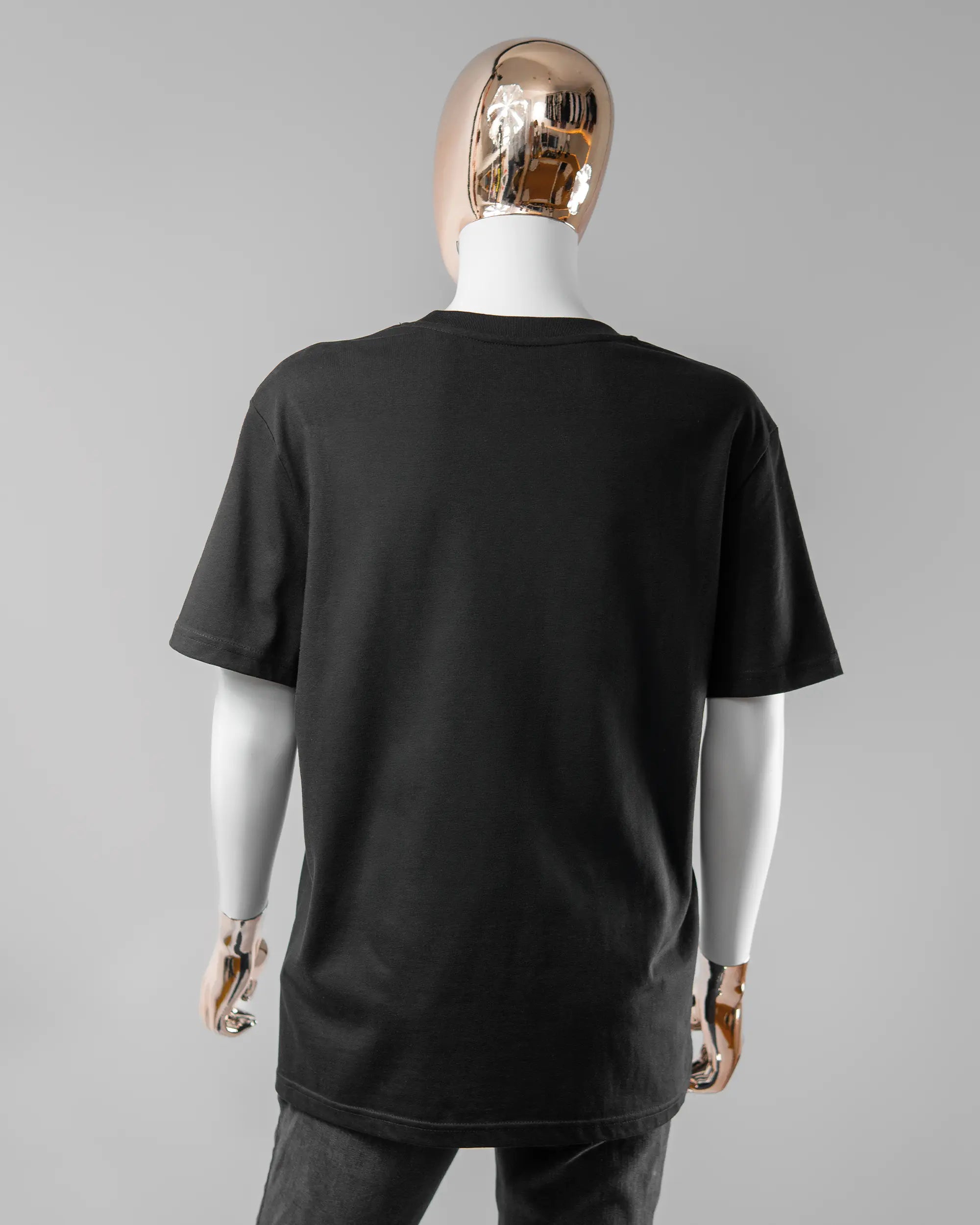 Rückseite des Organic Unisex T-Shirt Casual von Maondo ohne Motiv in der Farbe Black und in der Größe S getragen von einer femininen Puppe