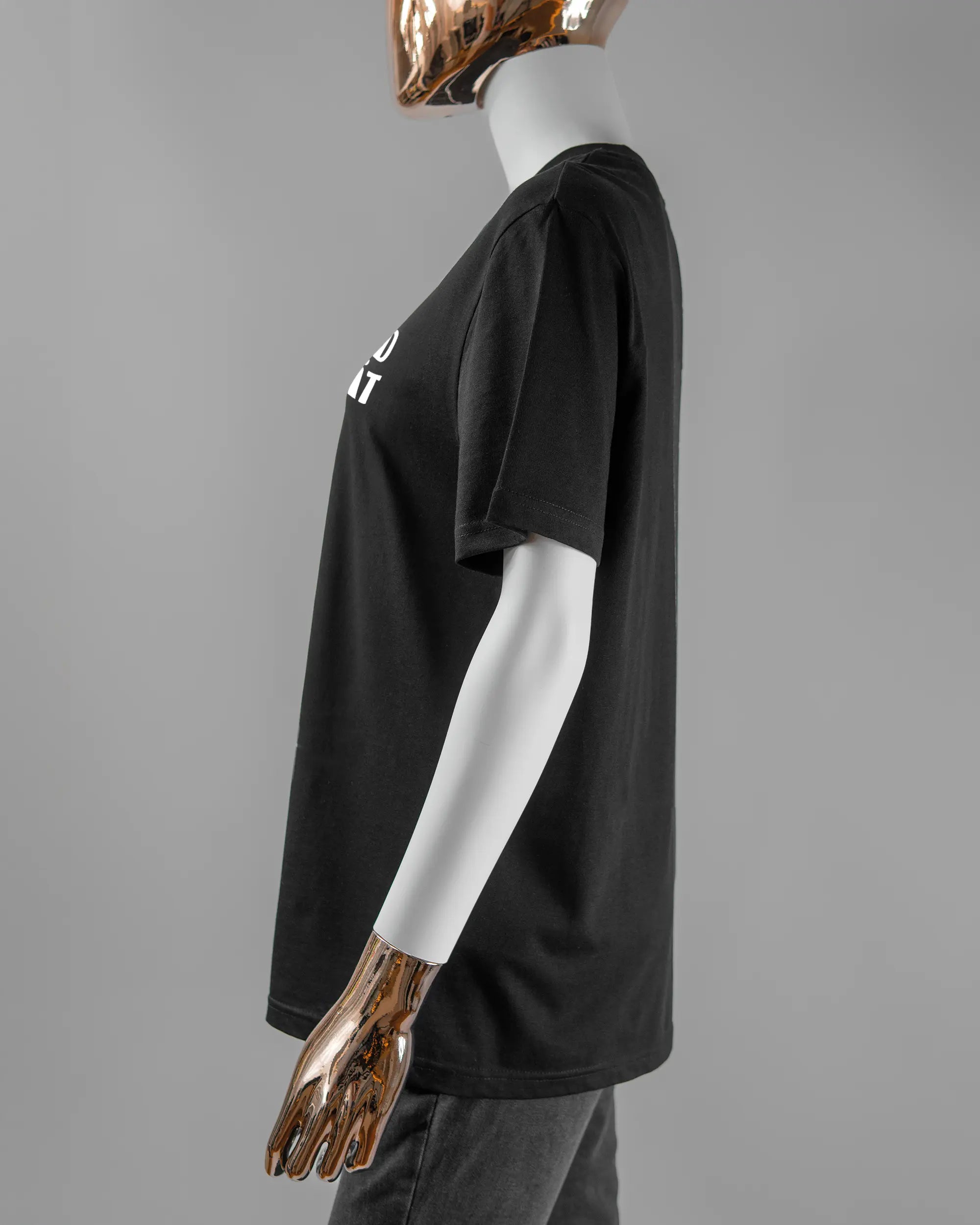 Seitenansicht des Organic Unisex T-Shirt Casual von Maondo mit dem Design Keine Eile vorne in der Farbe Black und in der Größe S getragen von einer femininen Puppe