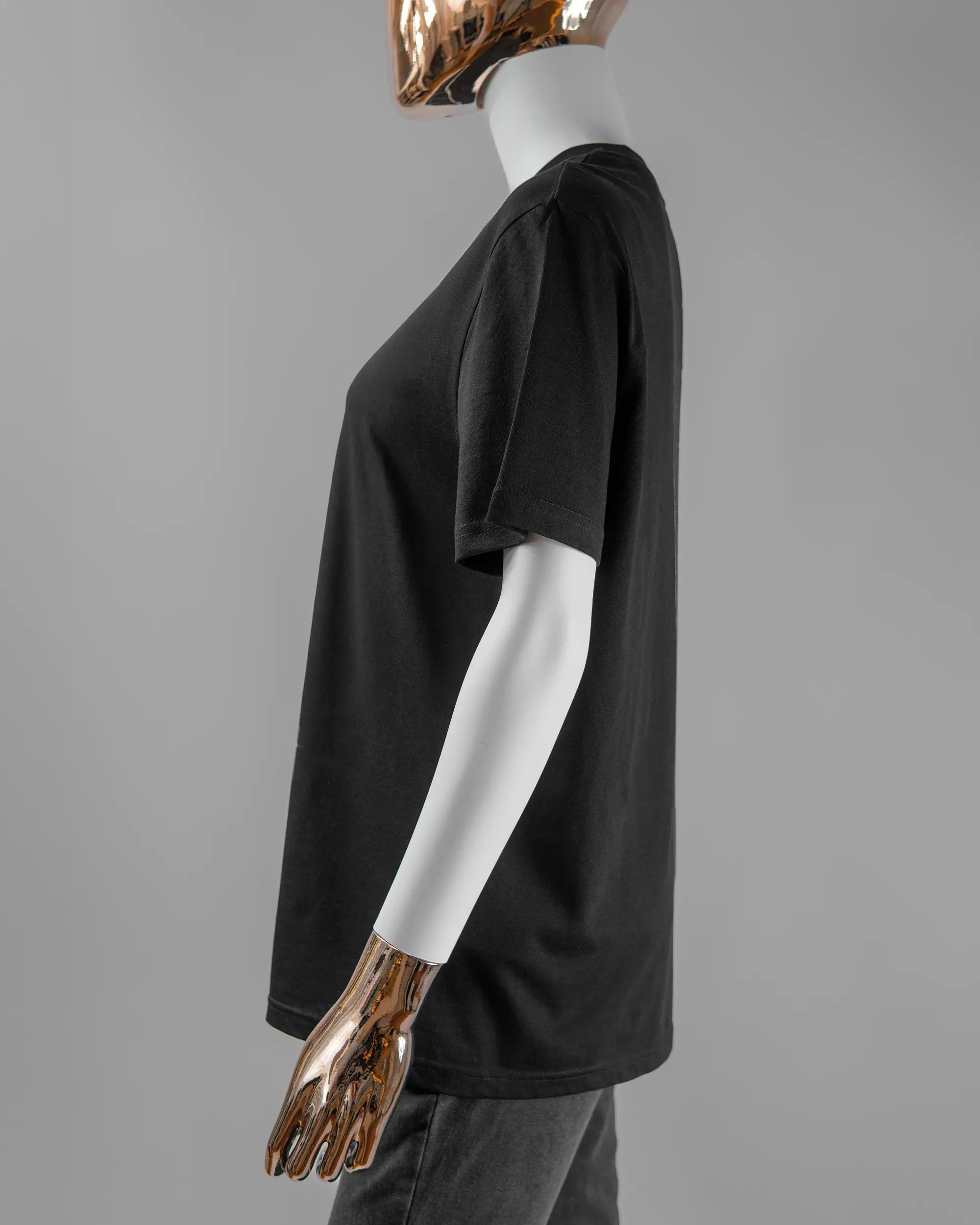 Seitenansicht des Organic Unisex T-Shirt Casual von Maondo mit dem Design Pigeon Pun vorne in der Farbe Black und in der Größe S getragen von einer femininen Puppe