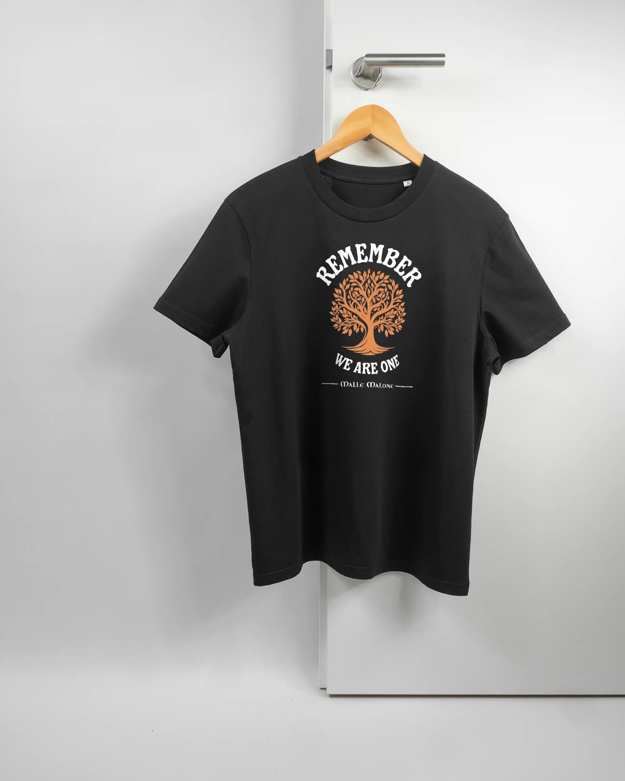 Vorderseite des Organic Unisex T-Shirt Casual von Maondo mit dem Design We are one in der Farbe Black und in der Größe S auf einem Bügel an der Türklinke aufgehängt