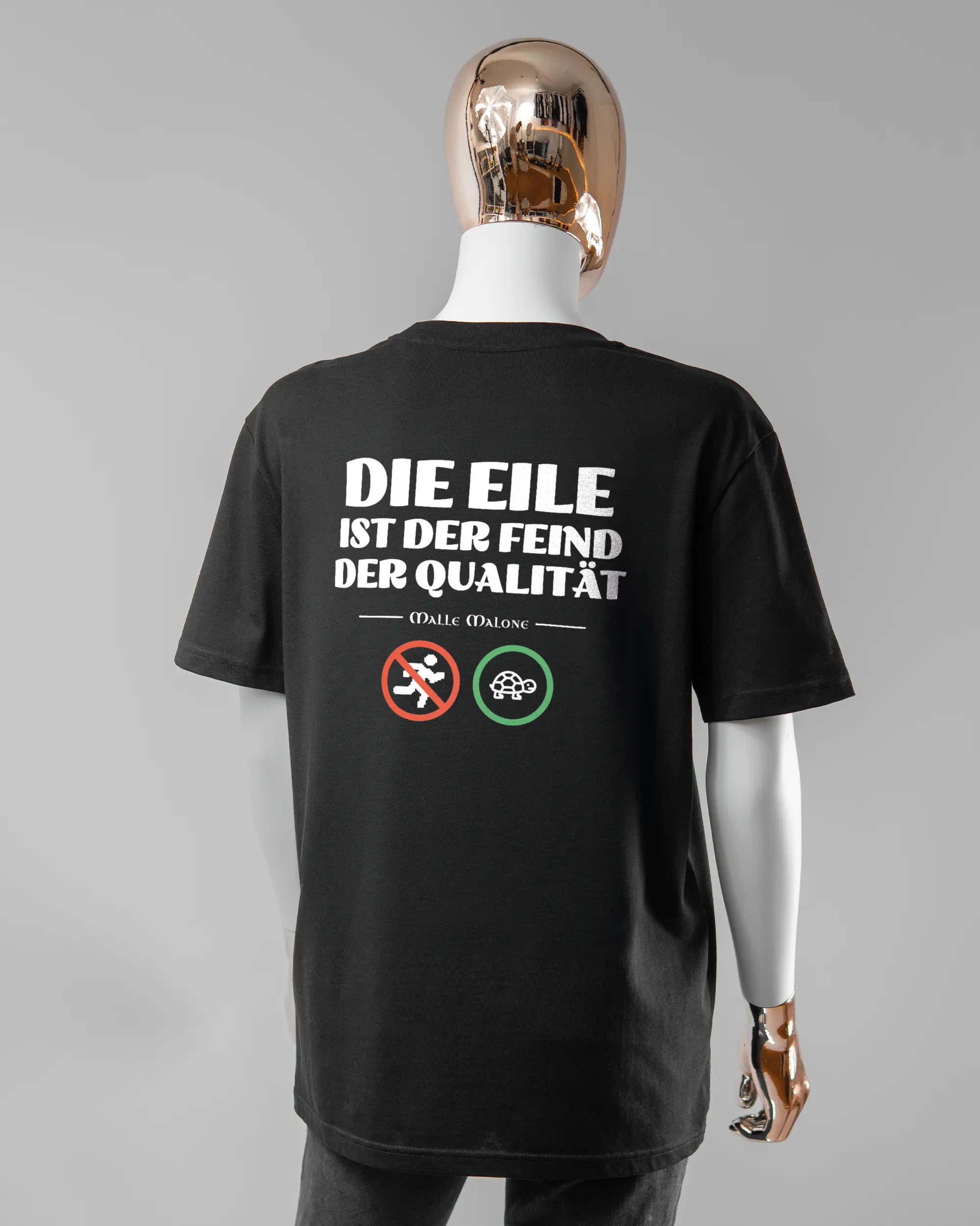 Rückseite des Organic Unisex T-Shirt Casual von Maondo mit dem Design Keine Eile in der Farbe Black und in der Größe S getragen von einer femininen Puppe