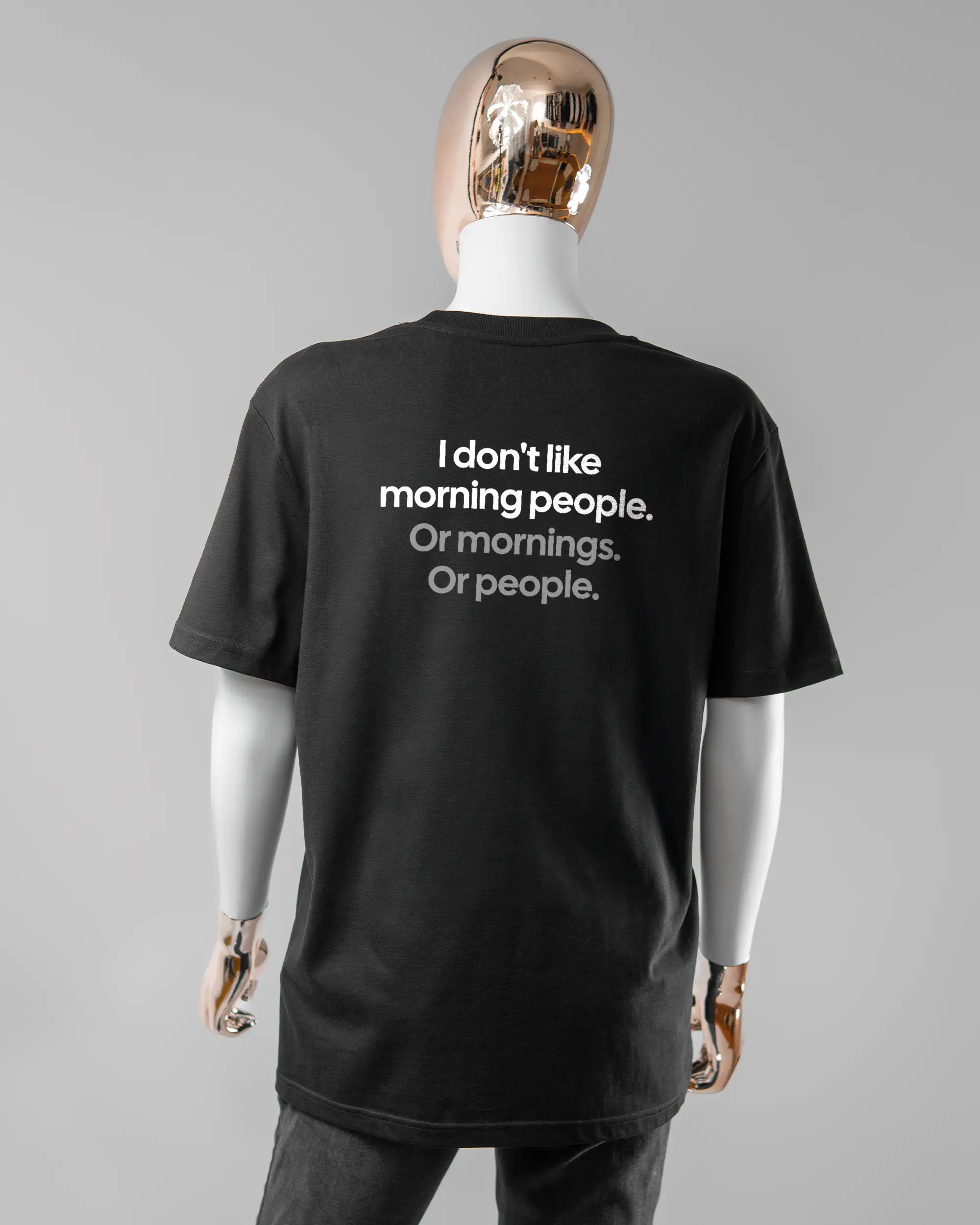 Rückseite des Organic Unisex T-Shirt Casual von Maondo mit dem Design Morning Person in der Farbe Black und in der Größe S getragen von einer femininen Puppe