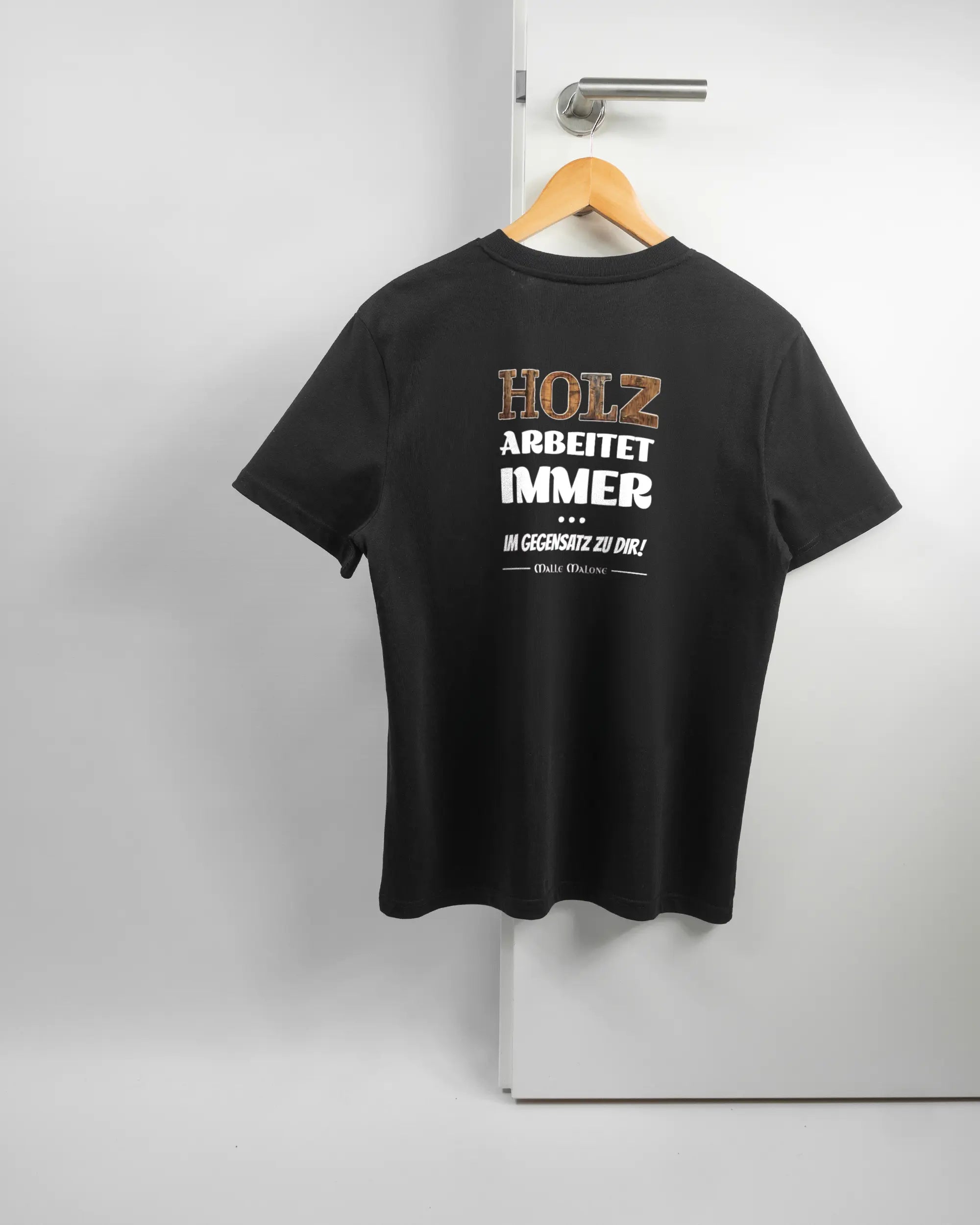 Rückseite des Organic Unisex T-Shirt Casual von Maondo mit dem Design Holzarbeit in der Farbe Black und in der Größe S auf einem Bügel an der Türklinke aufgehängt