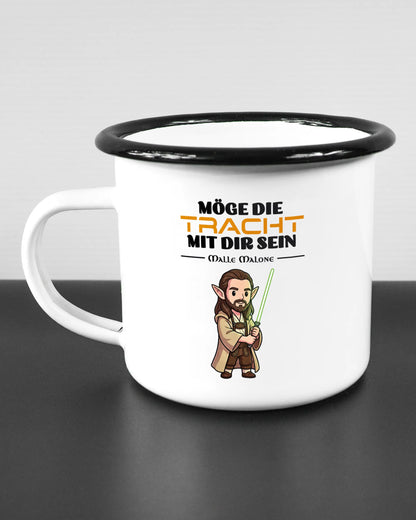 Titelbild, das die linke Seite der beidseitig bedruckten Emailletasse von Maondo mit dem Design Tracht mit dir in der Farbe White-Black auf einem Holztisch zeigt